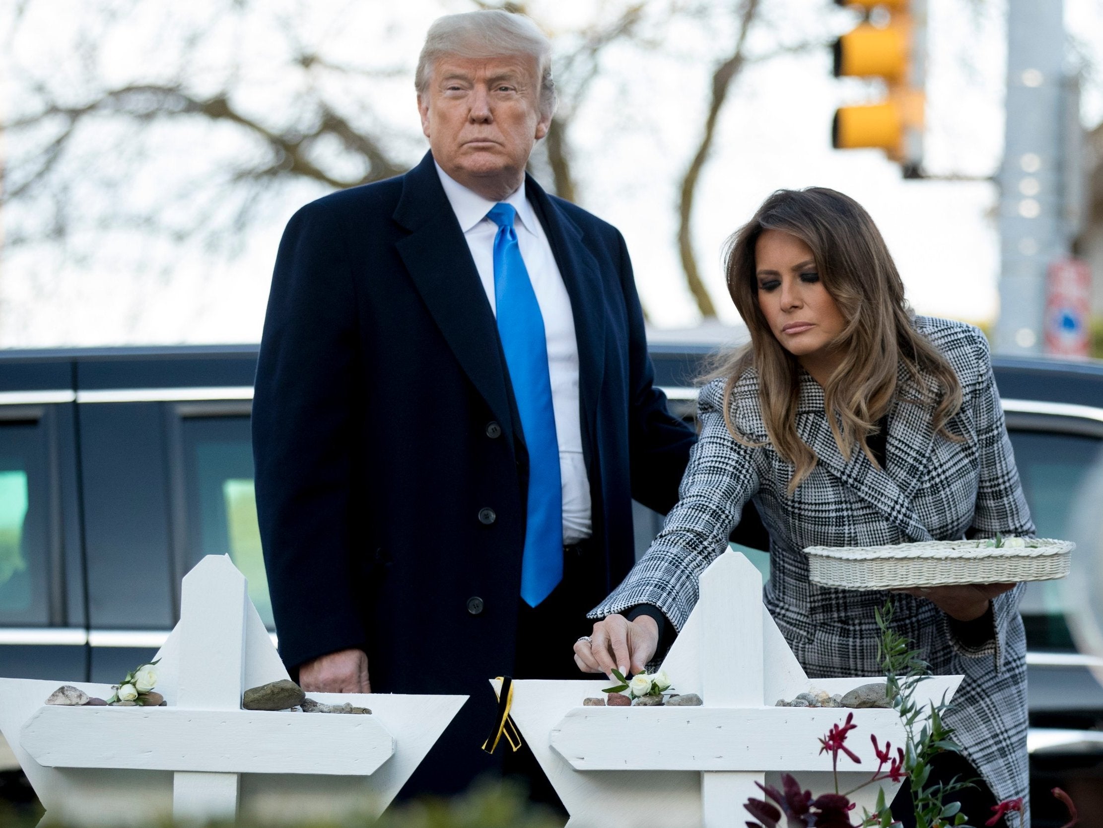 First lady Melania Trump puts down a white flower at a memorial for those killed at the Tree of Life Synagogue in Pittsburgh.