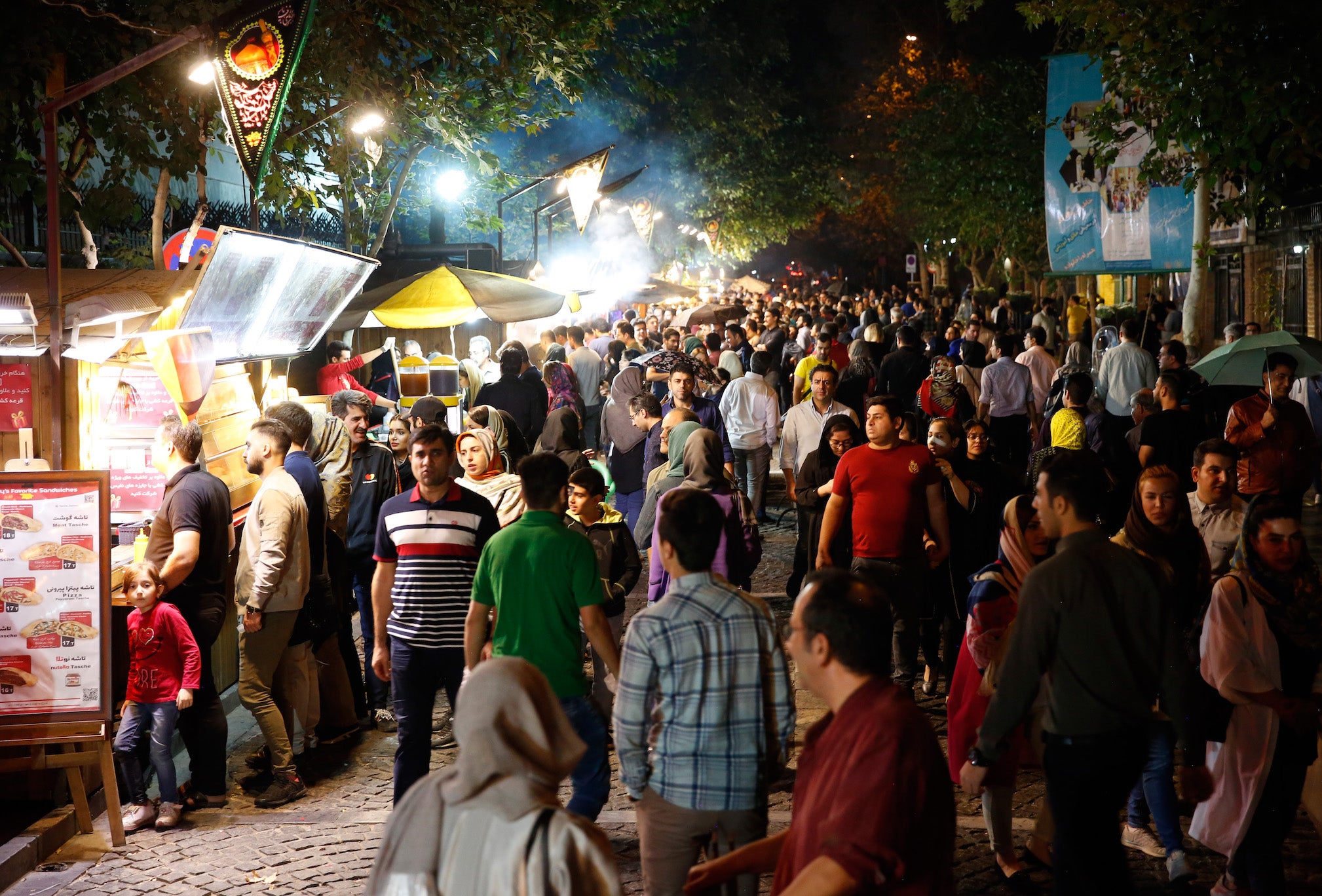 Iranians queue at a street food market in Tehran last month