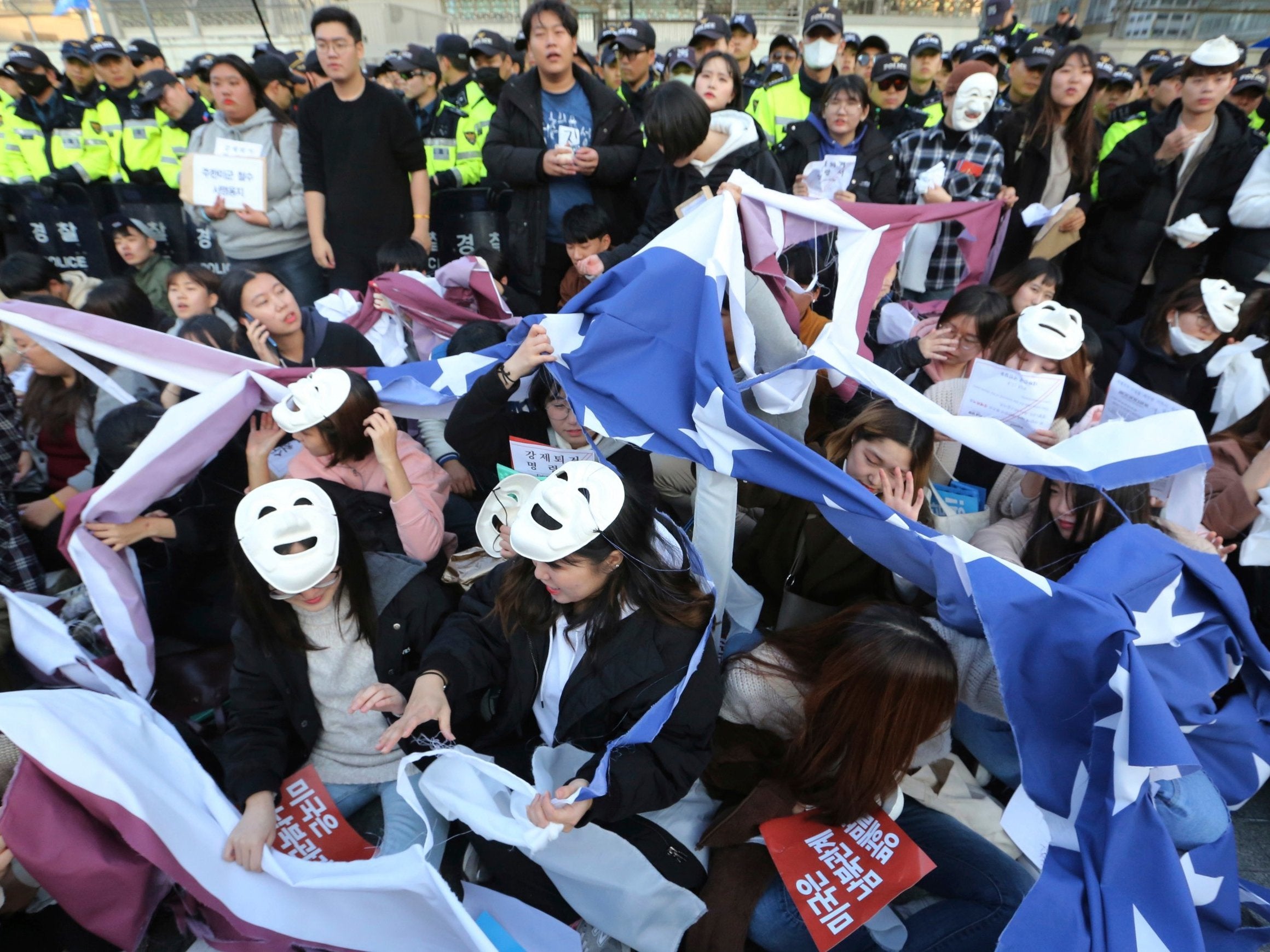 Protesters tear up a US flag during a rally in front of the embassy in Seoul, South Korea