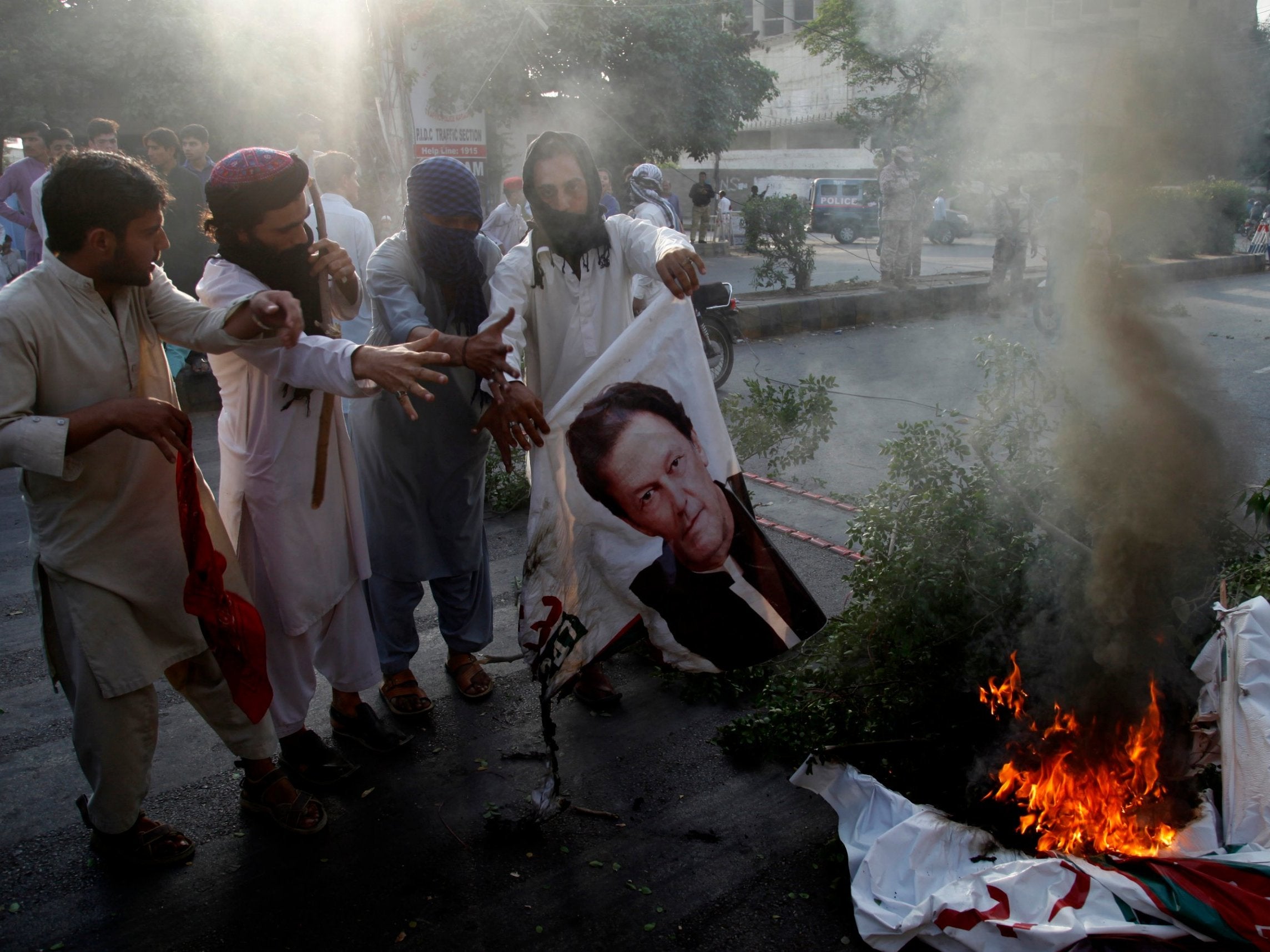 Islamist protesters burn a poster of Imran Khan after the acquittal of Asia Bibi