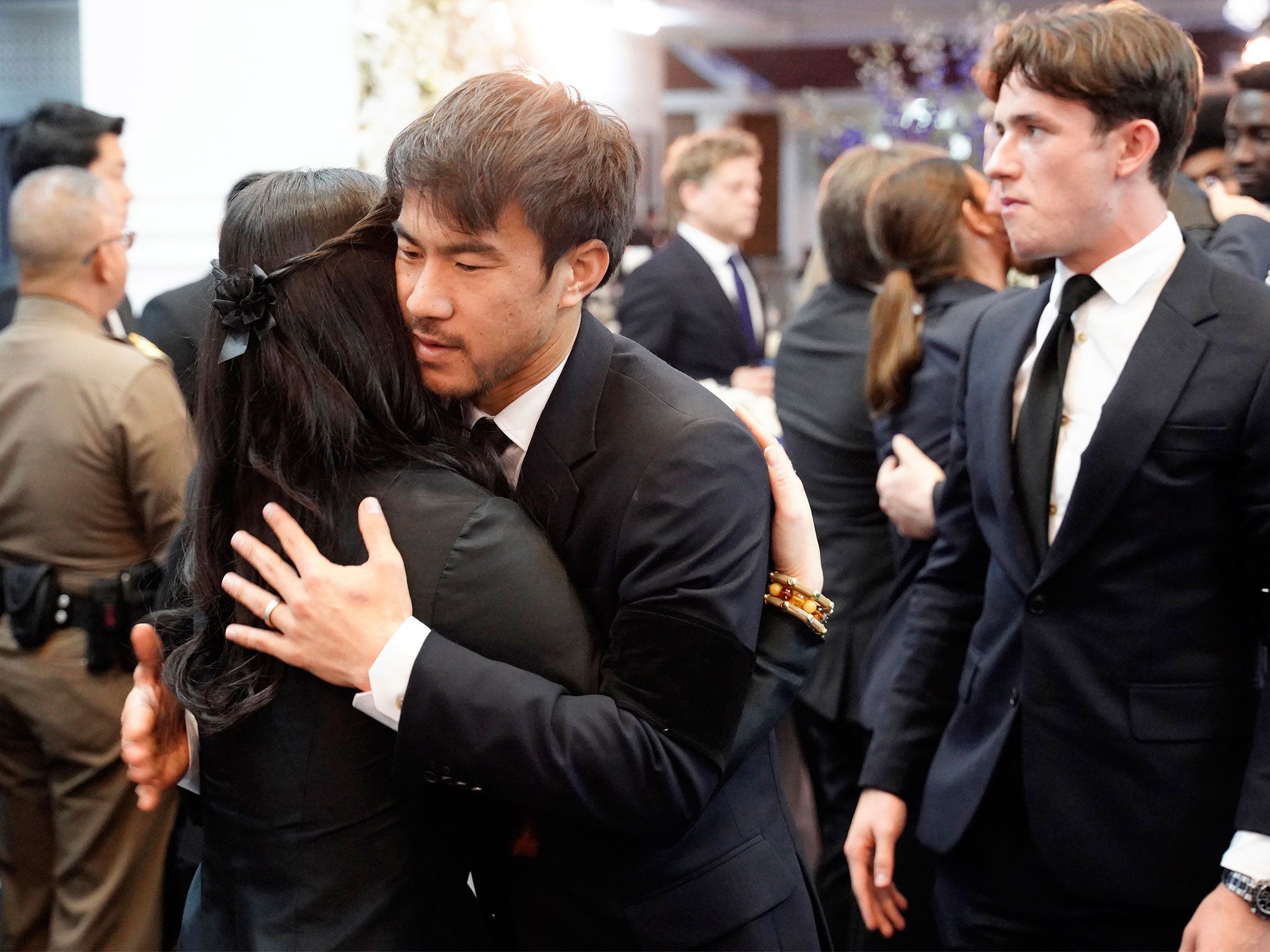 Shinji Okazaki embraces a woman during the service in Bangkok