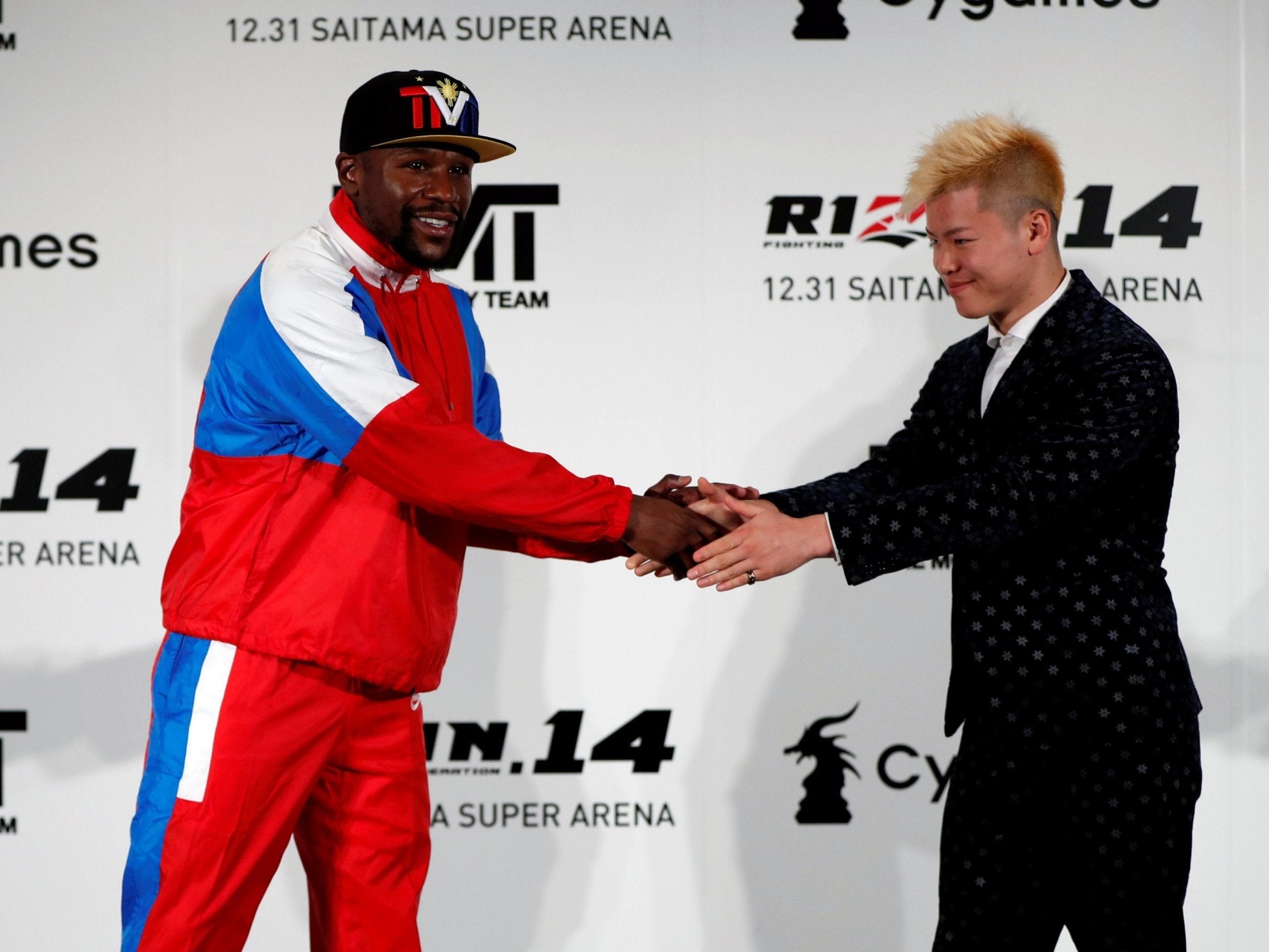 Mayweather shakes hands with Nasukawa at a press conference in Tokyo