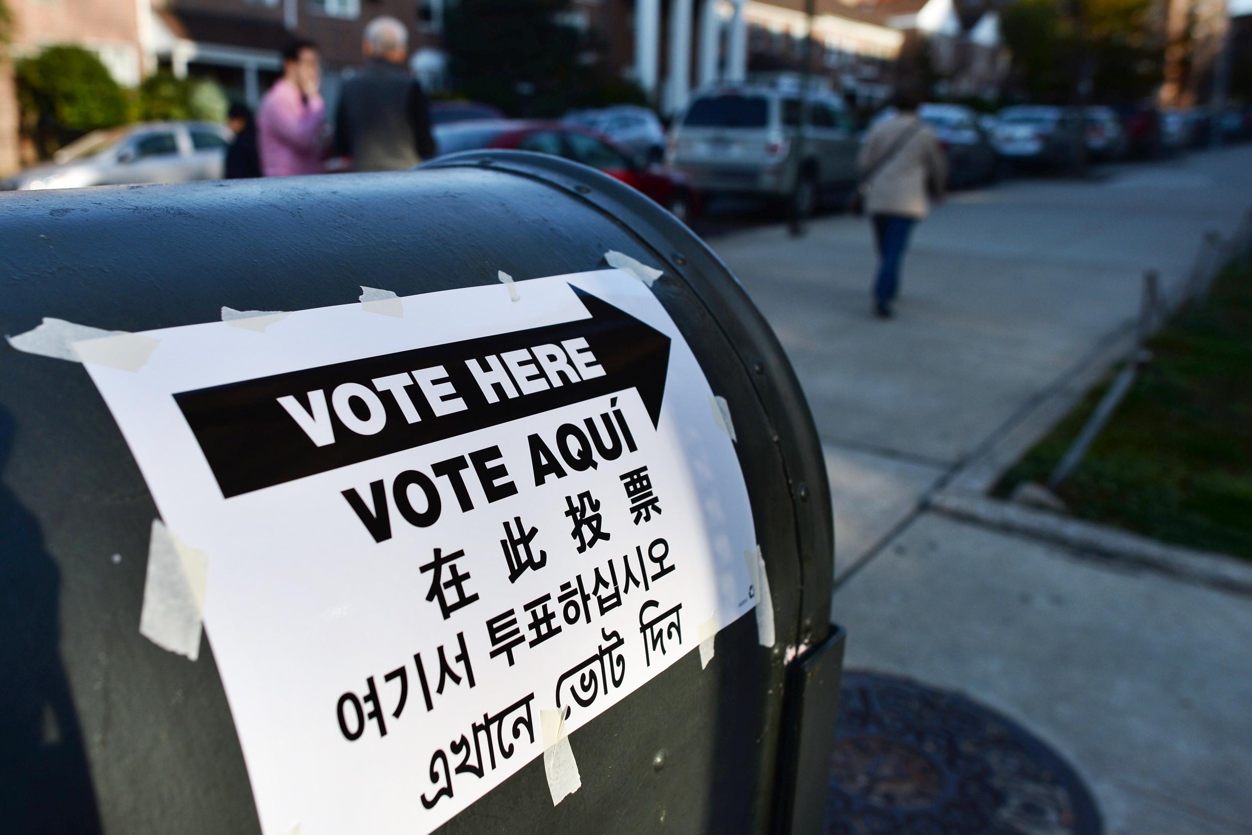 A directional sign in various languages is placed to point voters to a polling station in New York.