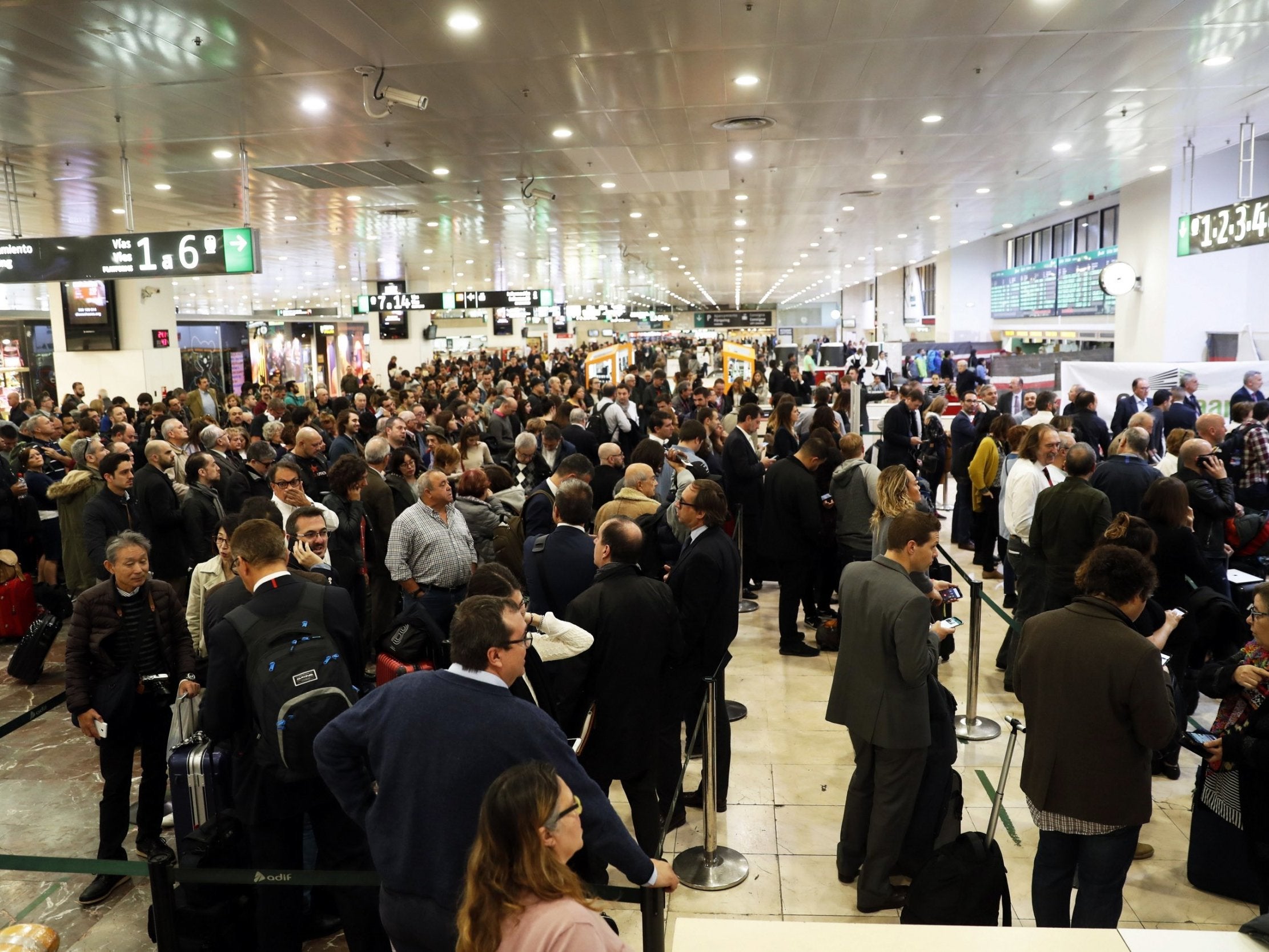 Travelers wait for information after trains evacuated at Sants station