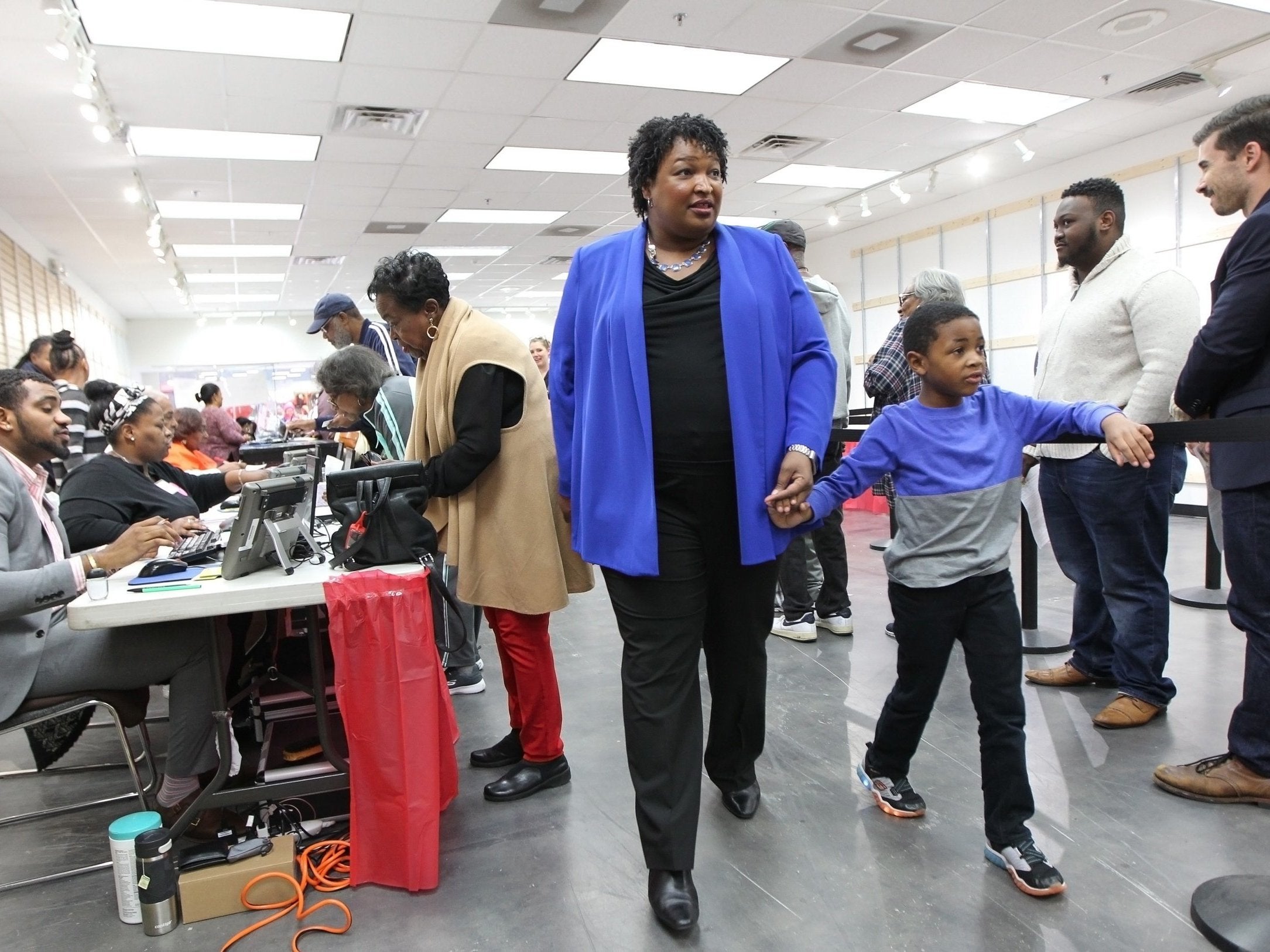 Stacey Abrams walks to a voting machine with her nephew in Decatur, Georgia