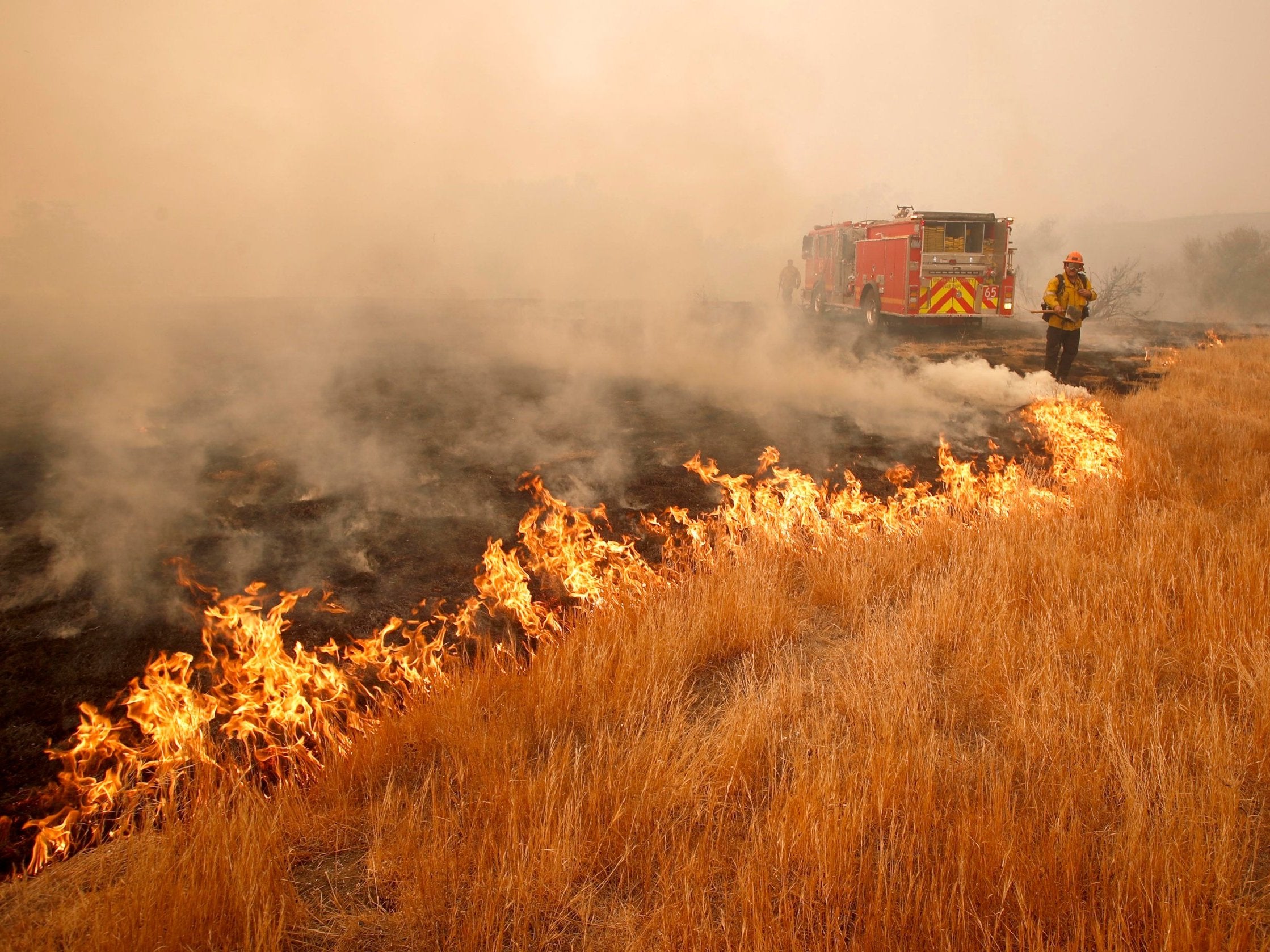 A firefighter battles a hotspot caused by the Woosley Fire in Malibu, California, 10 November 2018