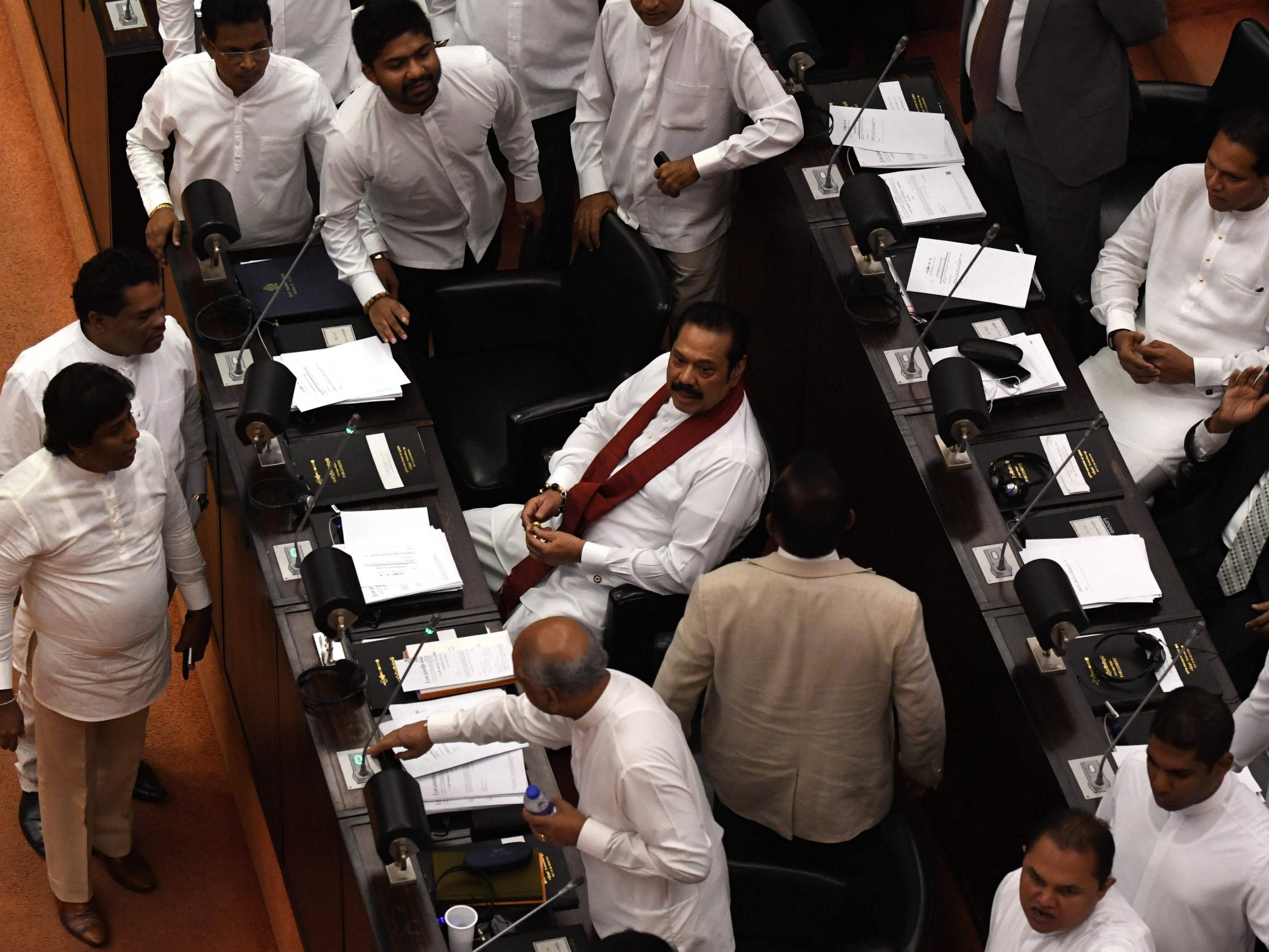 Sri Lanka's former president and currently appointed prime minister Mahinda Rajapaksa (C) attends the parliament session in Colombo