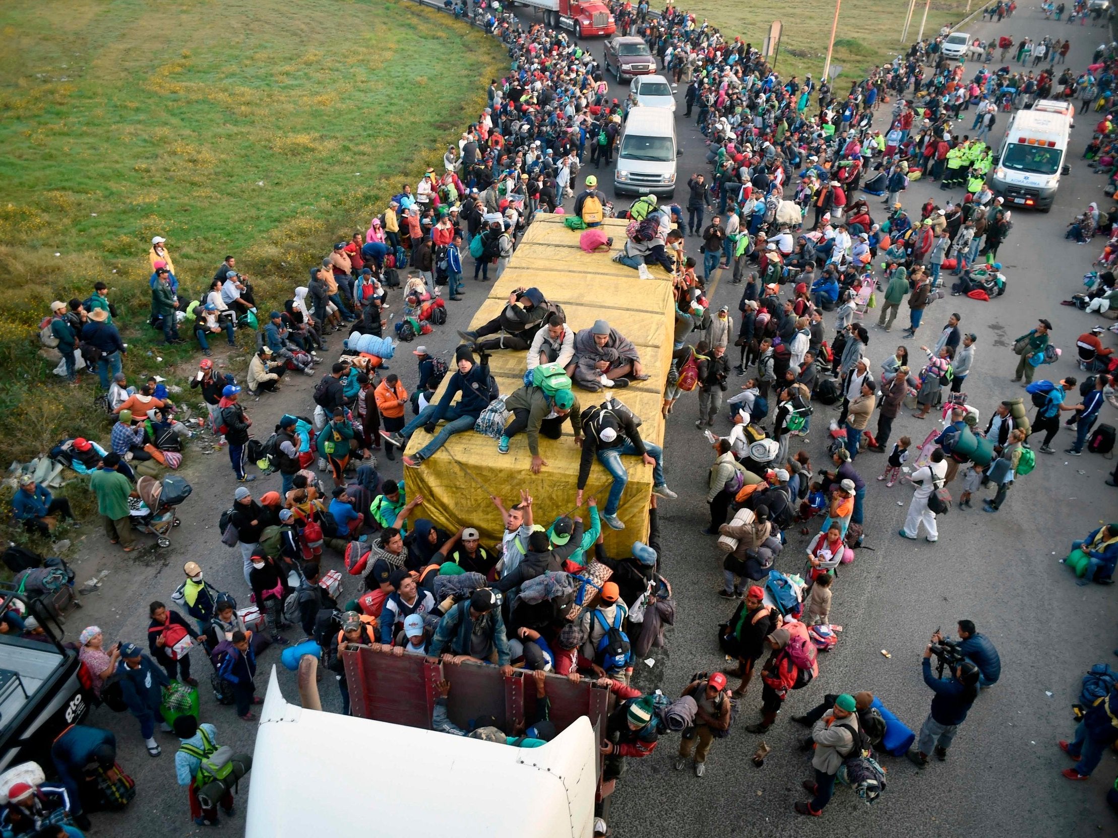 Migrants from poor Central American countries -mostly Hondurans wait along the Irapuato-Guadalajara highway for a ride to Guadalajara on their trek north, on November 12, 2018 (Alfredo Estrella/