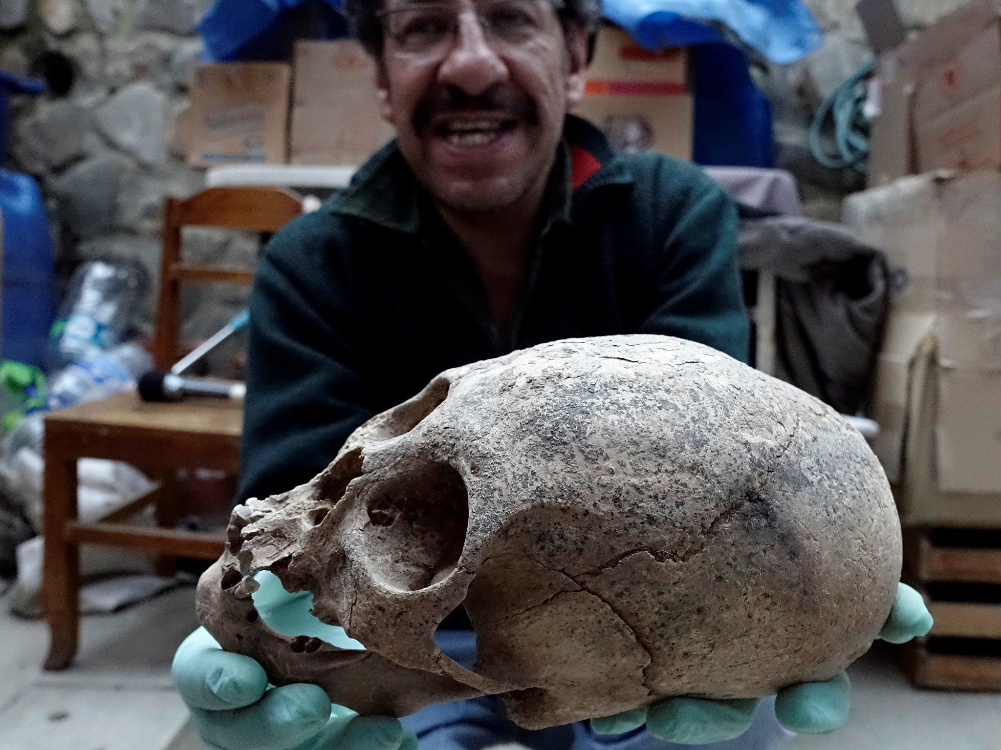 Archeologist Jedu Sagarnaga holds a skull as part of an archeological finding, dated approximately 500 years ago, in Mazo Cruz, near Viacha, Bolivia, November 12, 2018