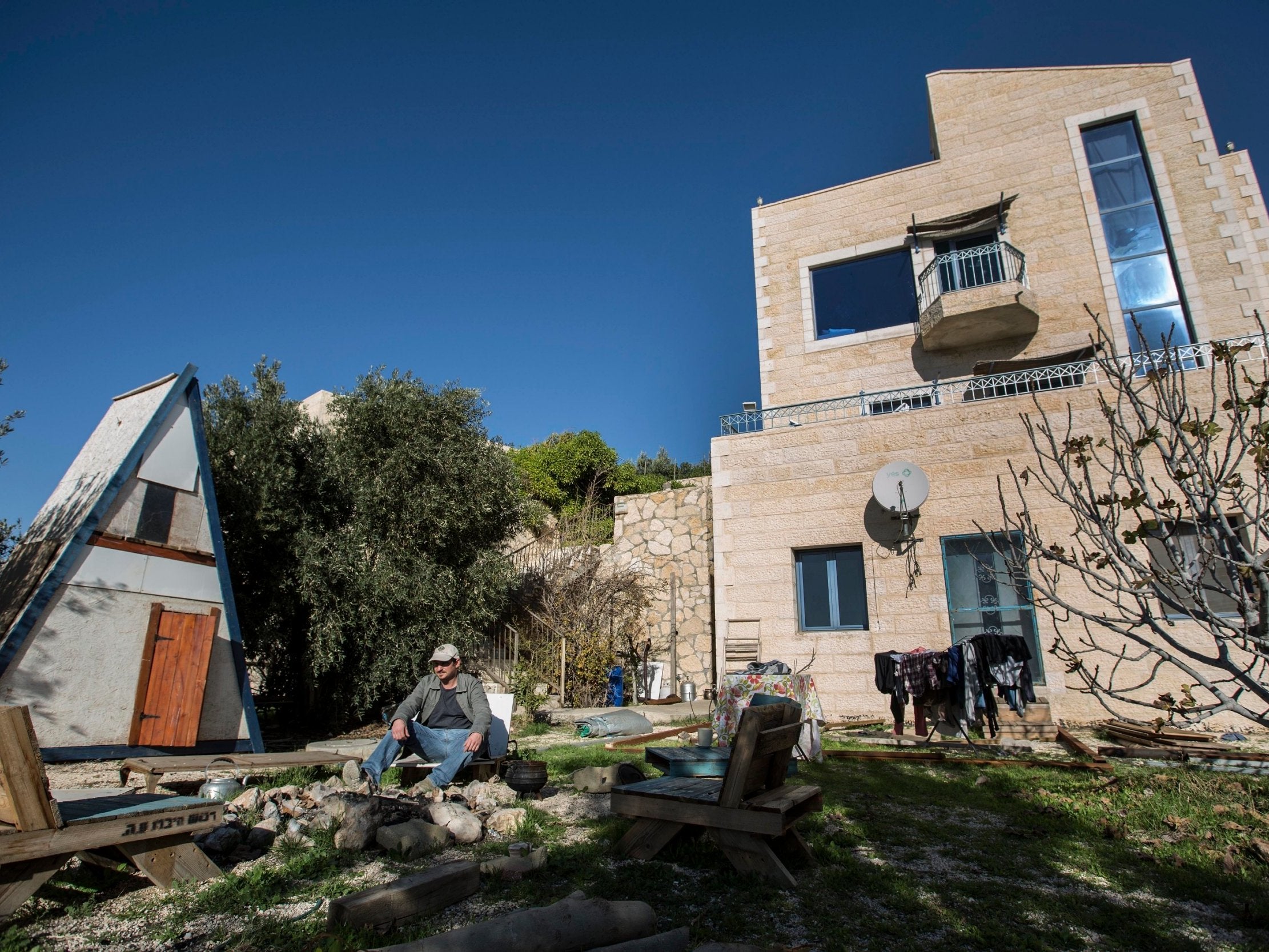 Moshe Gordon sits outside his guest house advertised on Airbnb, in the Nofei Prat settlement in the West Bank