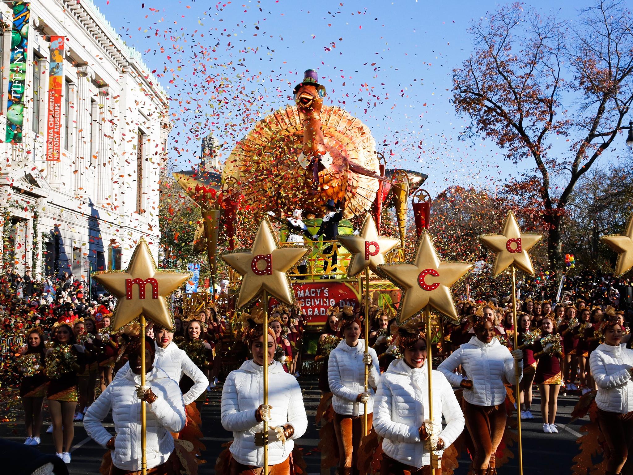 Performers walk in front of Macy's Tom Turkey float in the Thanksgiving Day Parade in New York