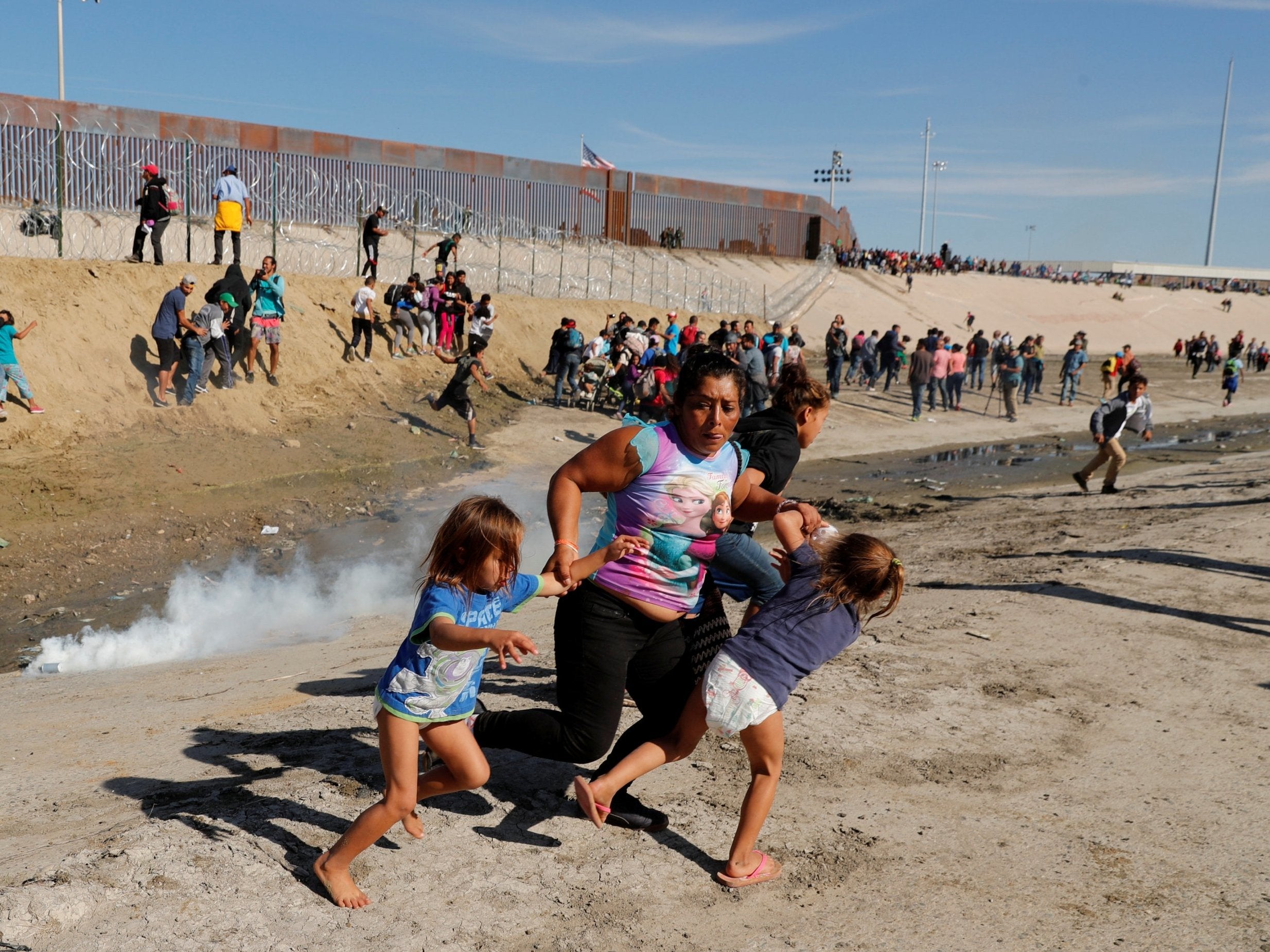 A woman and her children escape the teargas at the US-Mexico border