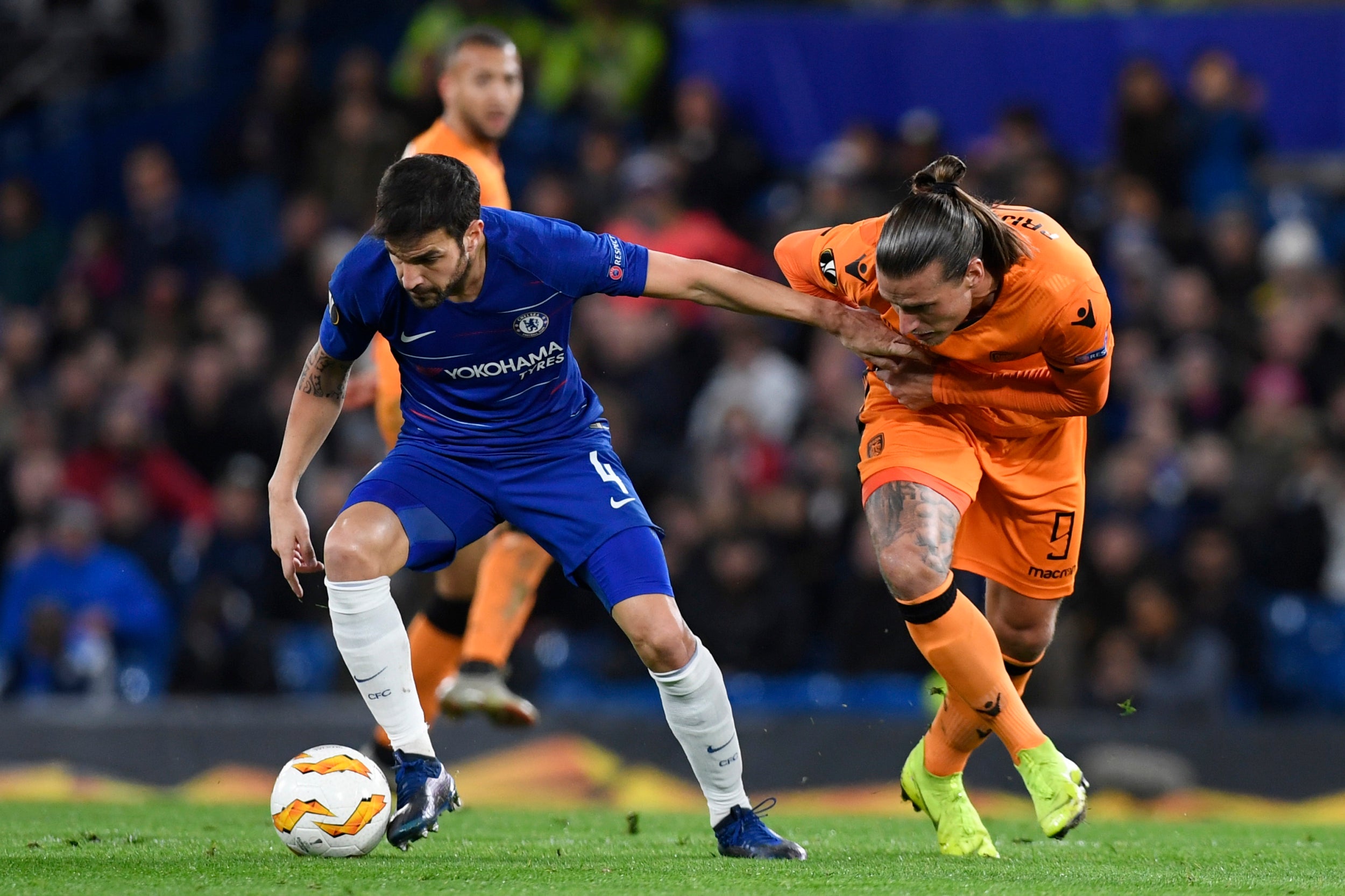 Cesc Fabregas holds off a PAOK marker