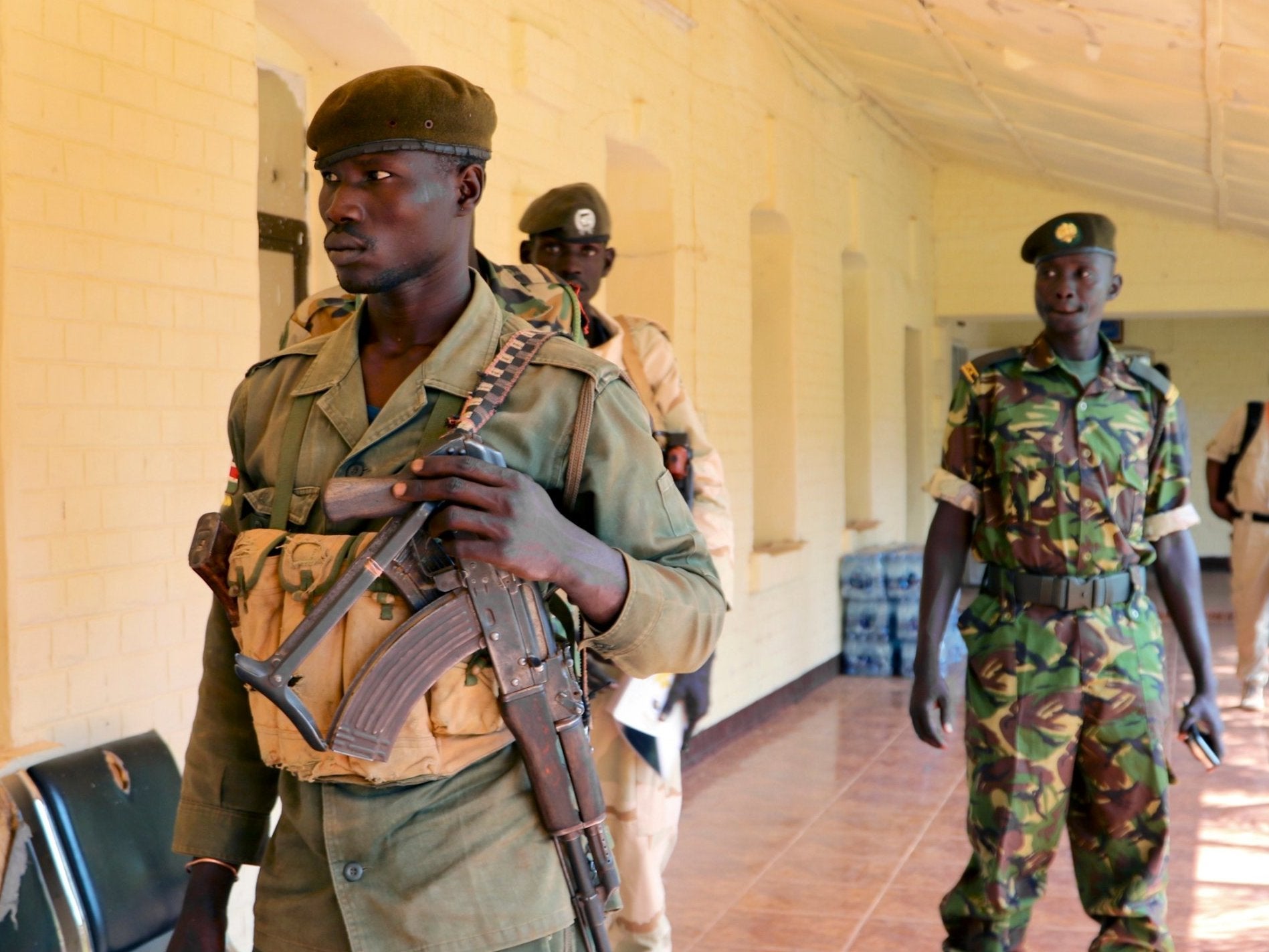 Soldiers from both sides stand guard outside a high-level meeting between government and opposition commanders, where both sides exchanged accusations of violating the peace agreement, 22 November