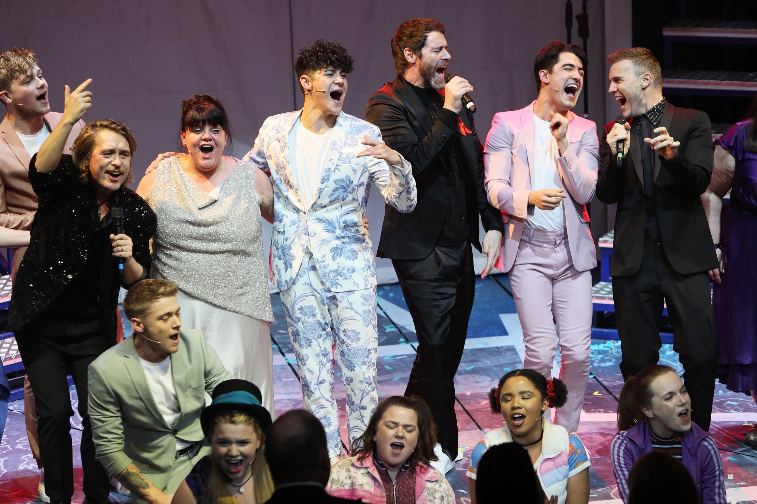 Mark Owen, Howard Donald and Gary Barlow of Take That perform with cast members (Dave Benett/Getty)