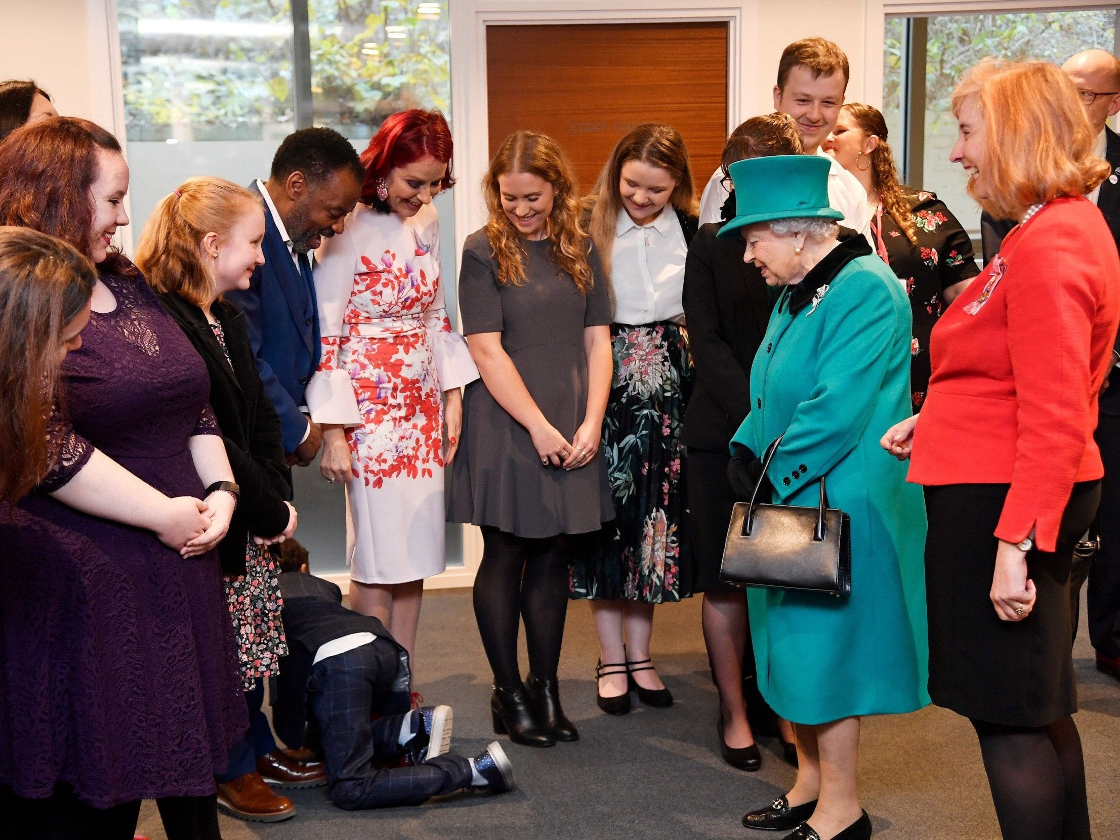 A boy crawls away during a visit by Queen Elizabeth II to Coram, the UK's oldest children's charity, to open the Queen Elizabeth II Centre at its base in central London.