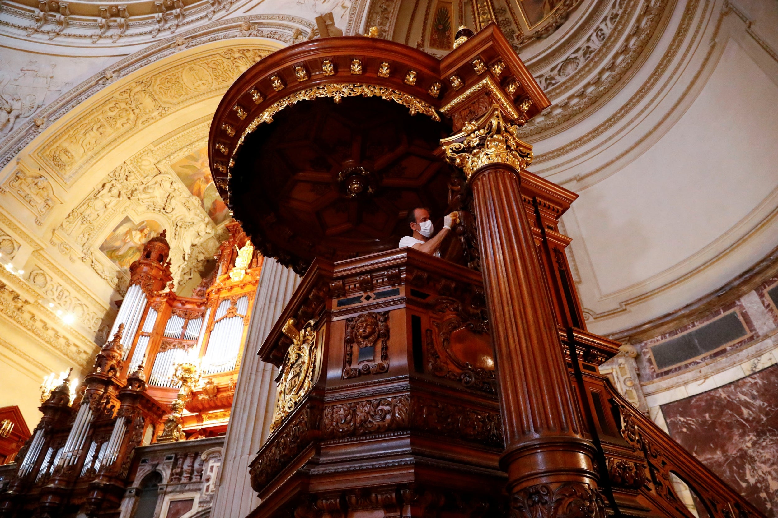 Joseph Saliba, a Syrian migrant of Christian background, lacquers a church ambo at the Berlin Cathedral