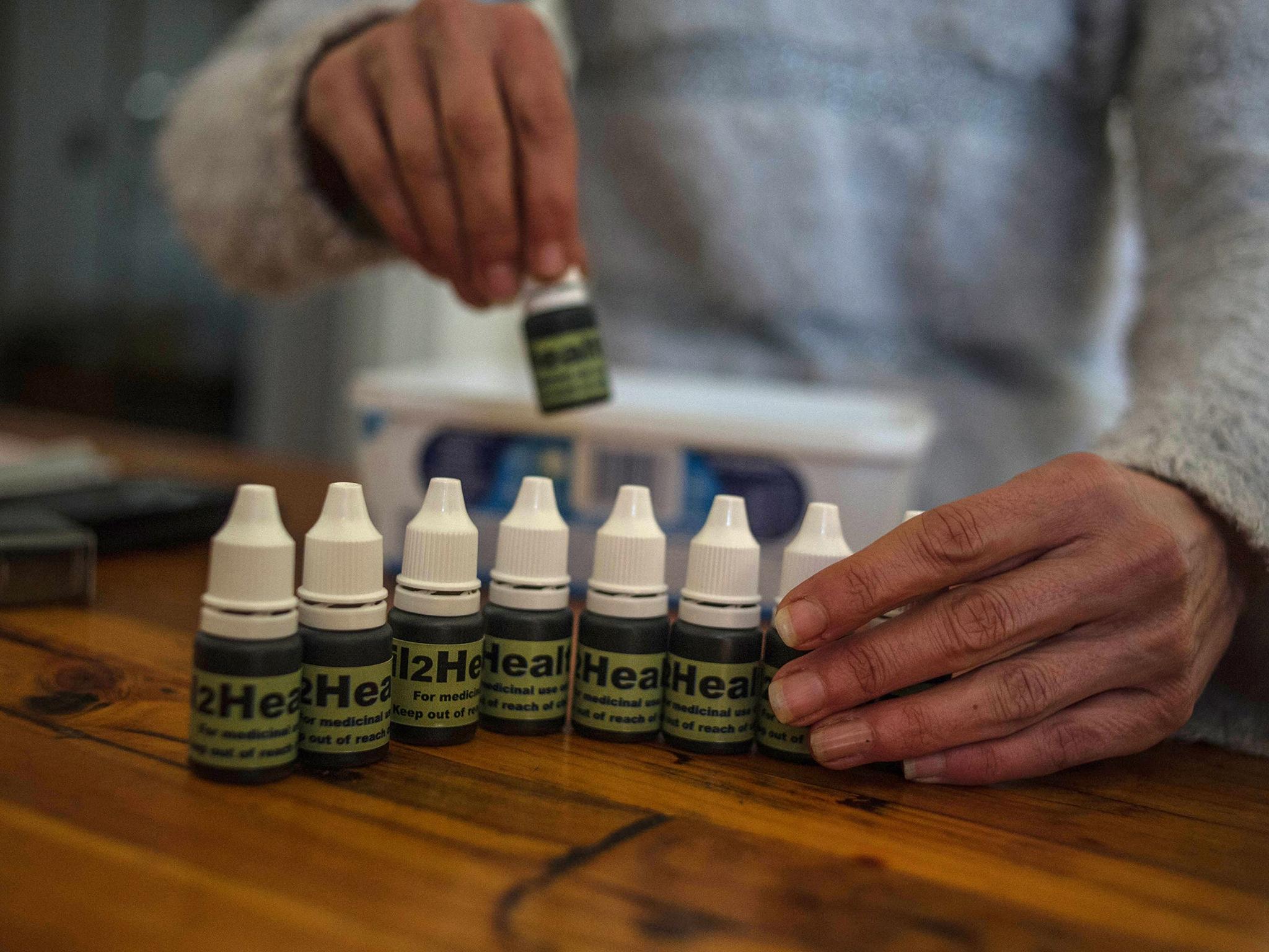 South African Gerd Bader, who has multiple sclerosis and manufactures concentrated cannabis oil, shows oil produced from plants at his Johannesburg home (AFP/Getty)