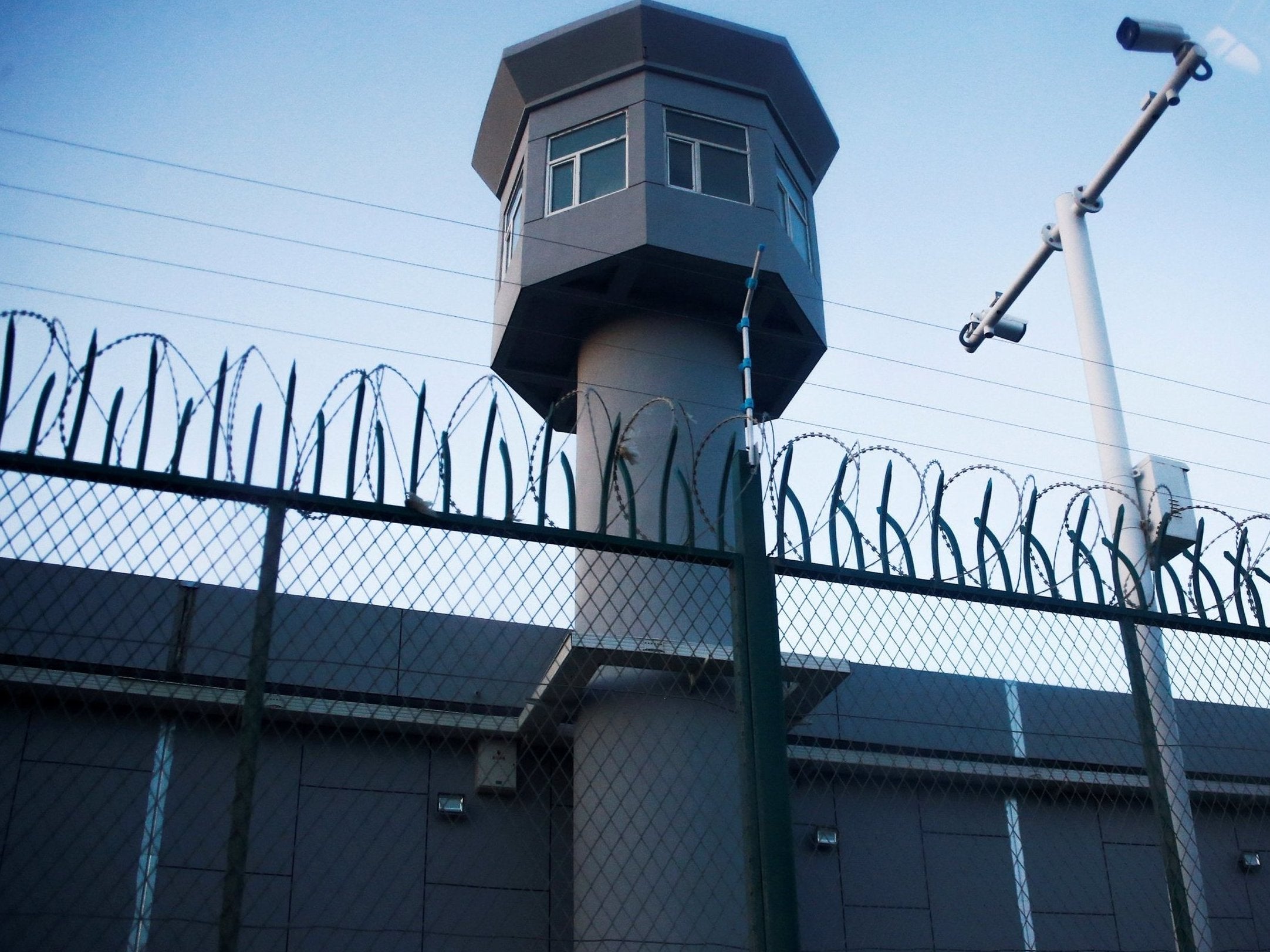 A guard watchtower rises along a perimeter fence of what is officially known as a vocational skills education centre in Dabancheng in Xinjiang (Reuters/Thomas Peter)