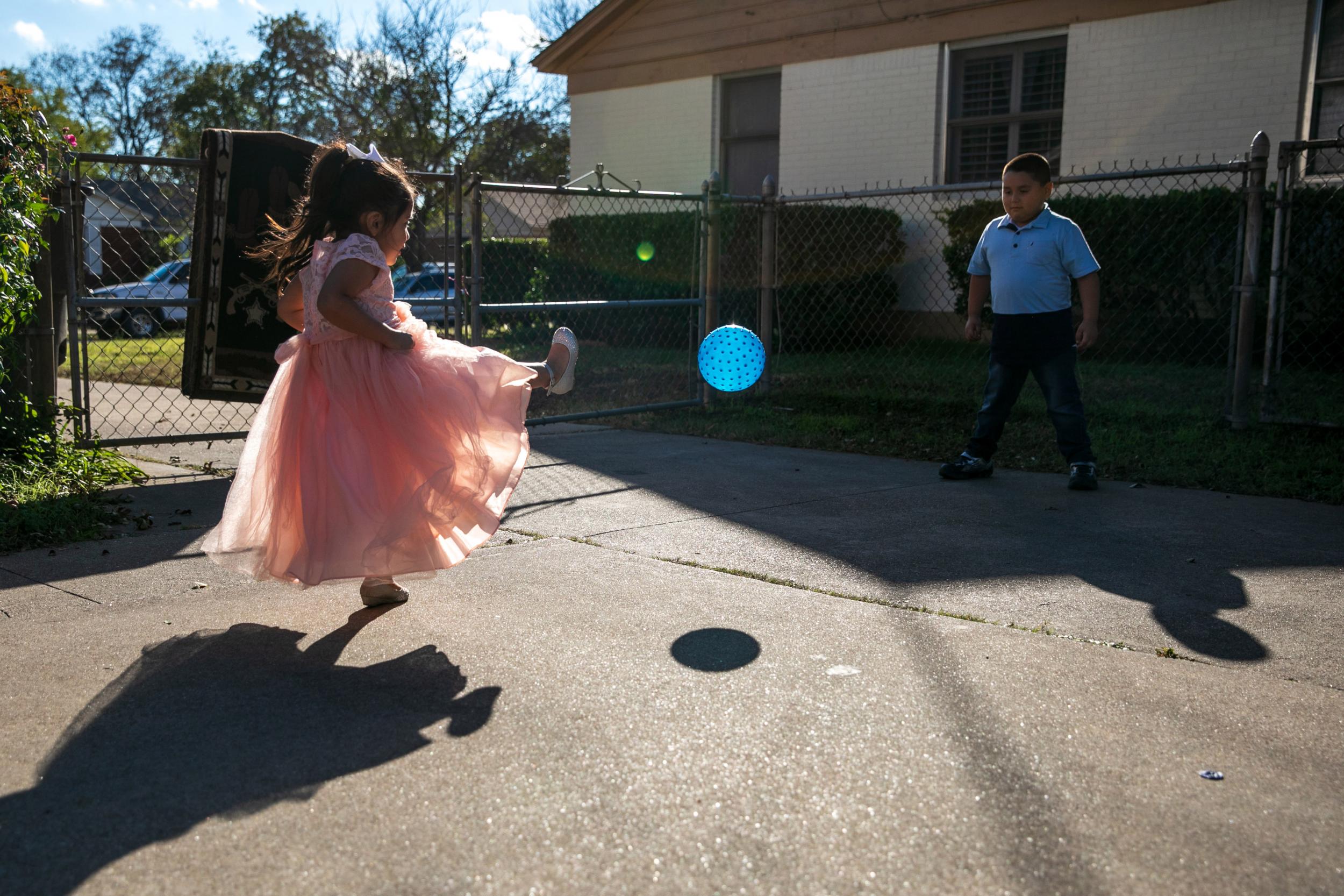 Alyson Cisneros kicks a ball to brother Axel at their grandparents’ home