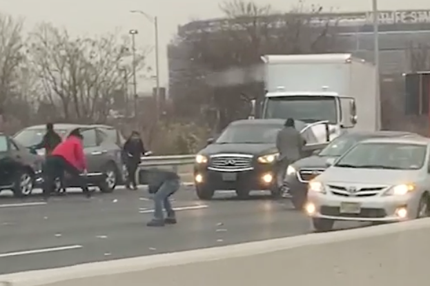 People were seen on the highway amid trucks and cars.