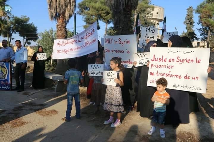 Ahlam and other protestors hold signs for detained people (Mohamed Karkas)