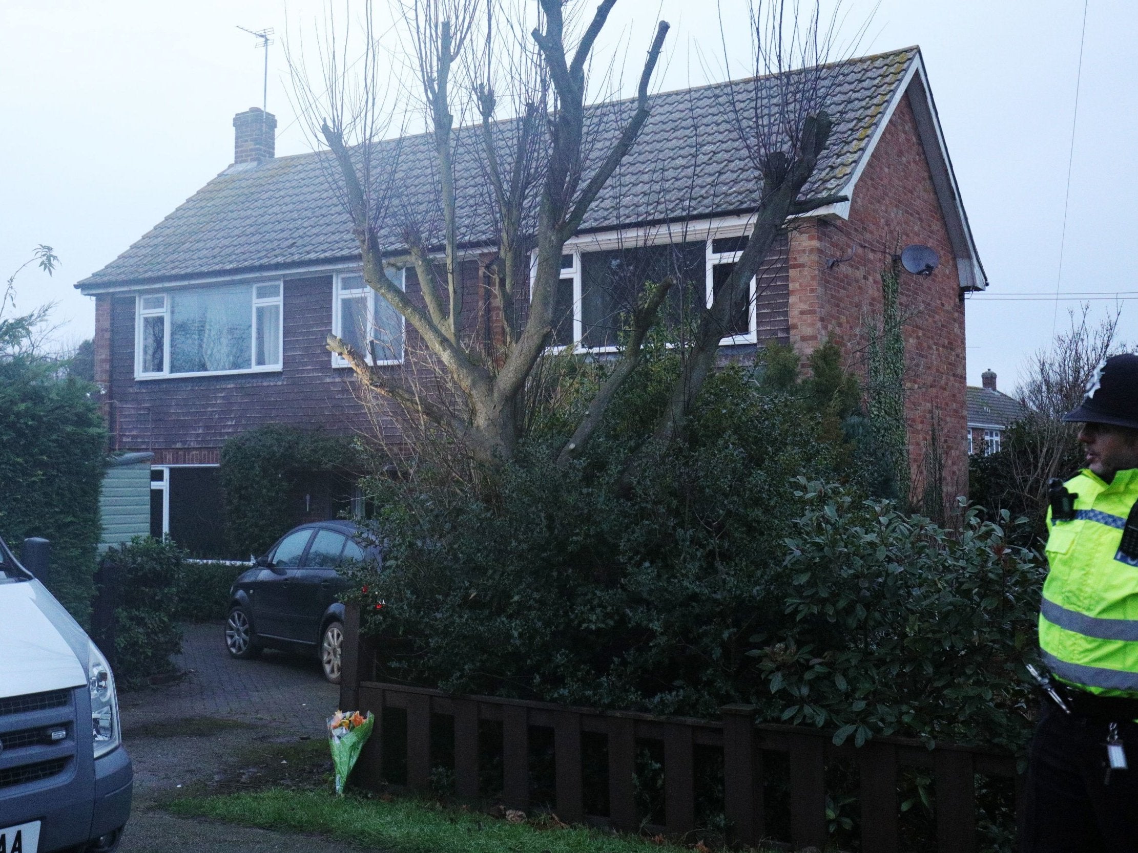 A police officer stands behind a cordon following the house fire in Collingham