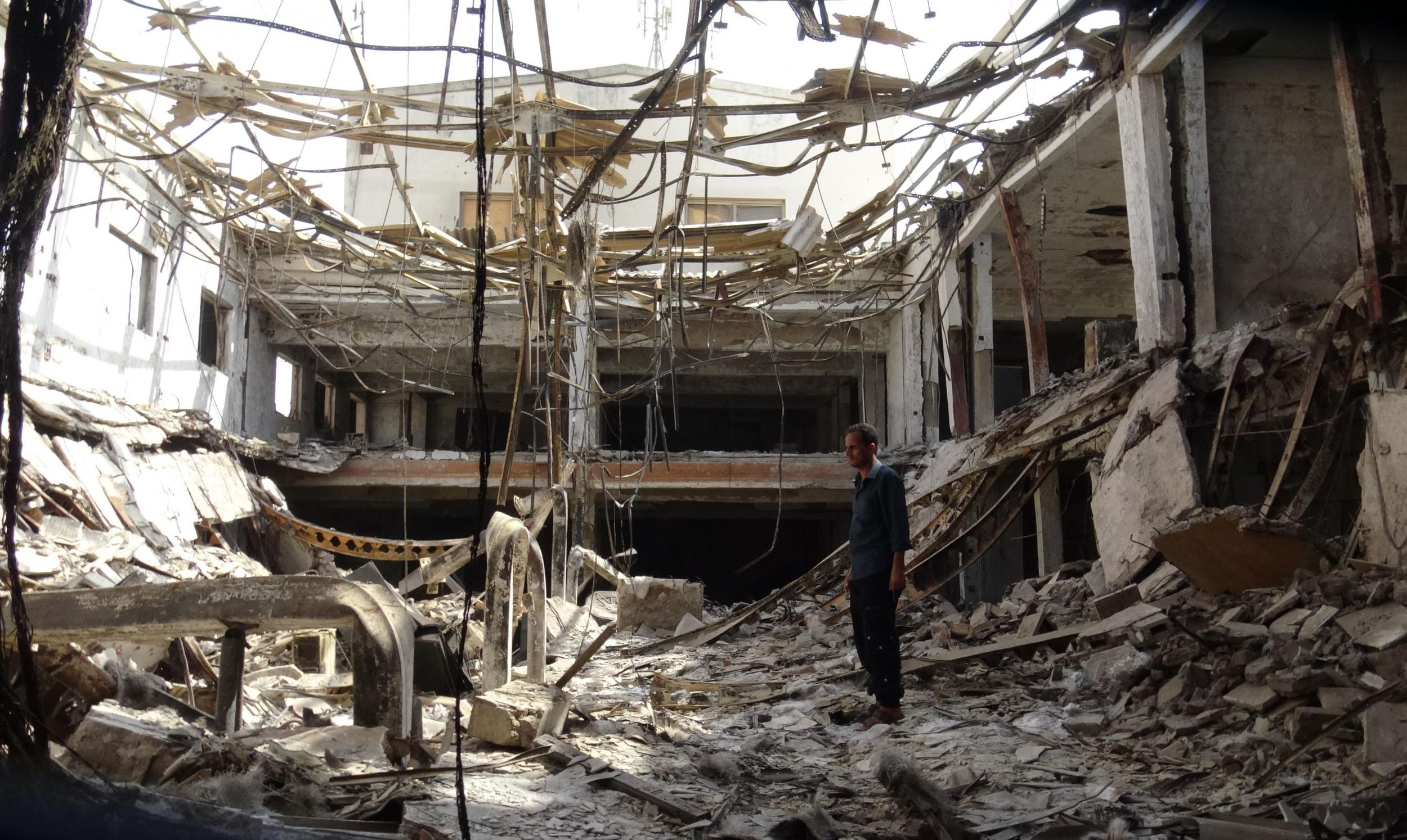 A man stands amidst the rubble at a factory damaged during fighting and air strikes in Hodeidah as ceasefire comes into effect