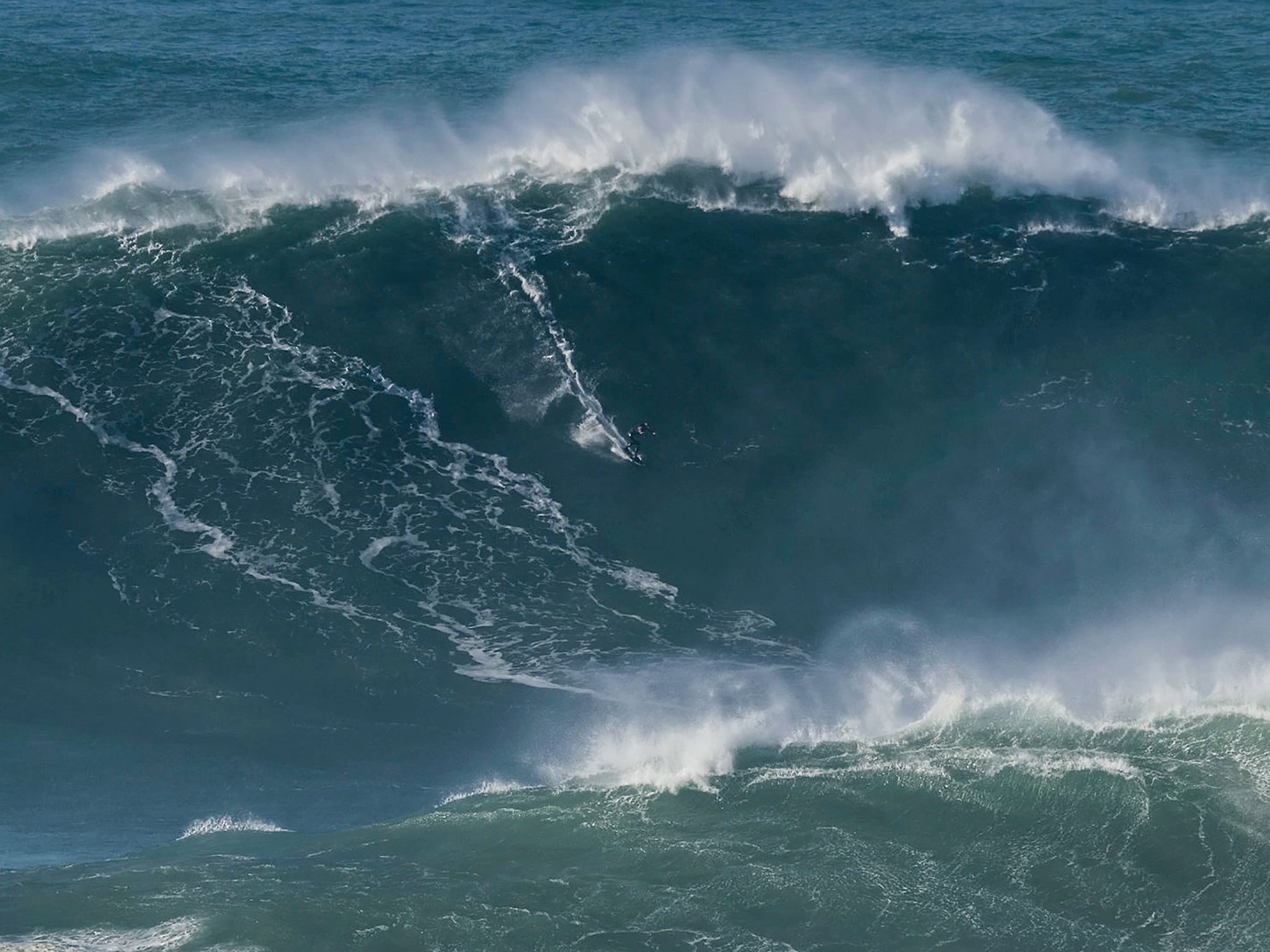 Tom Butler riding the wave estimated to be a more than 100ft tall at Nazare in Portugal