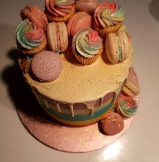 The couple's colourful wedding cake was decorated with macarons and mini cupcakes