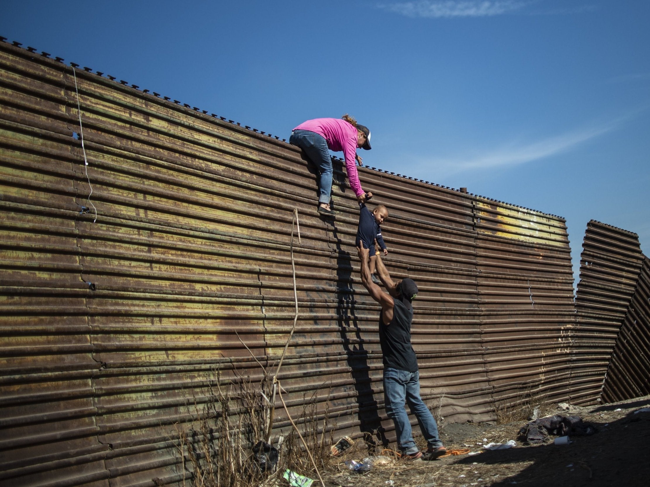 The Trump administration built 458 miles of primary and secondary border fencing and walls, most of it replacing dilapidated barriers that already existed. A group of migrants attempt to climb the border fence between Mexico and the United States, near El Chaparral border crossing, in Tijuana, Baja California State, Mexico, on November 25, 2018.