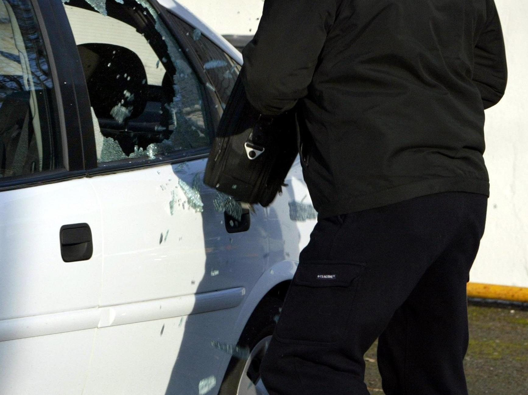 Thief breaking into a car