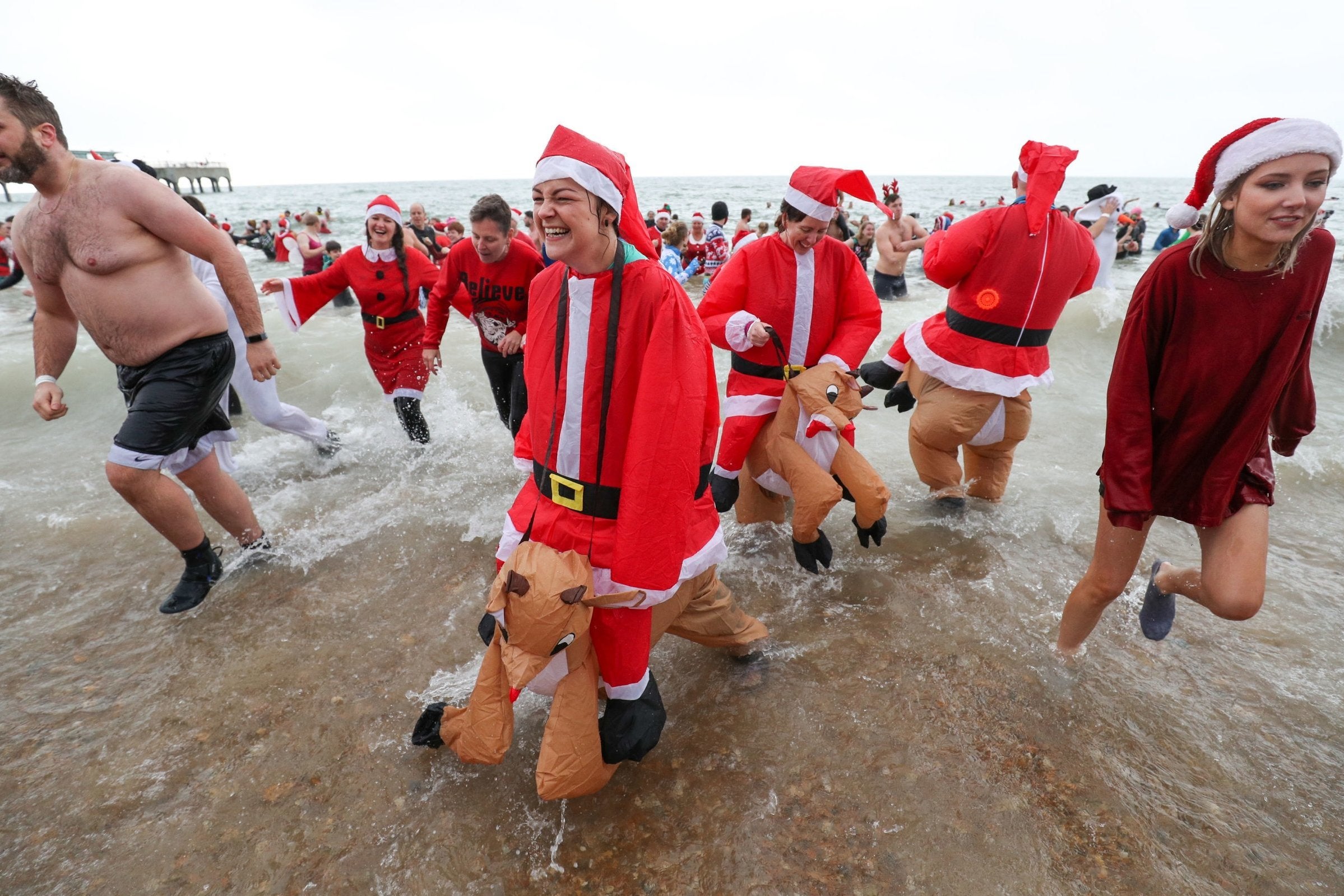 Swimmers dressed in full Santa Claus outfits for the annual swim at Boscombe Pier in Bournemouth(PA)