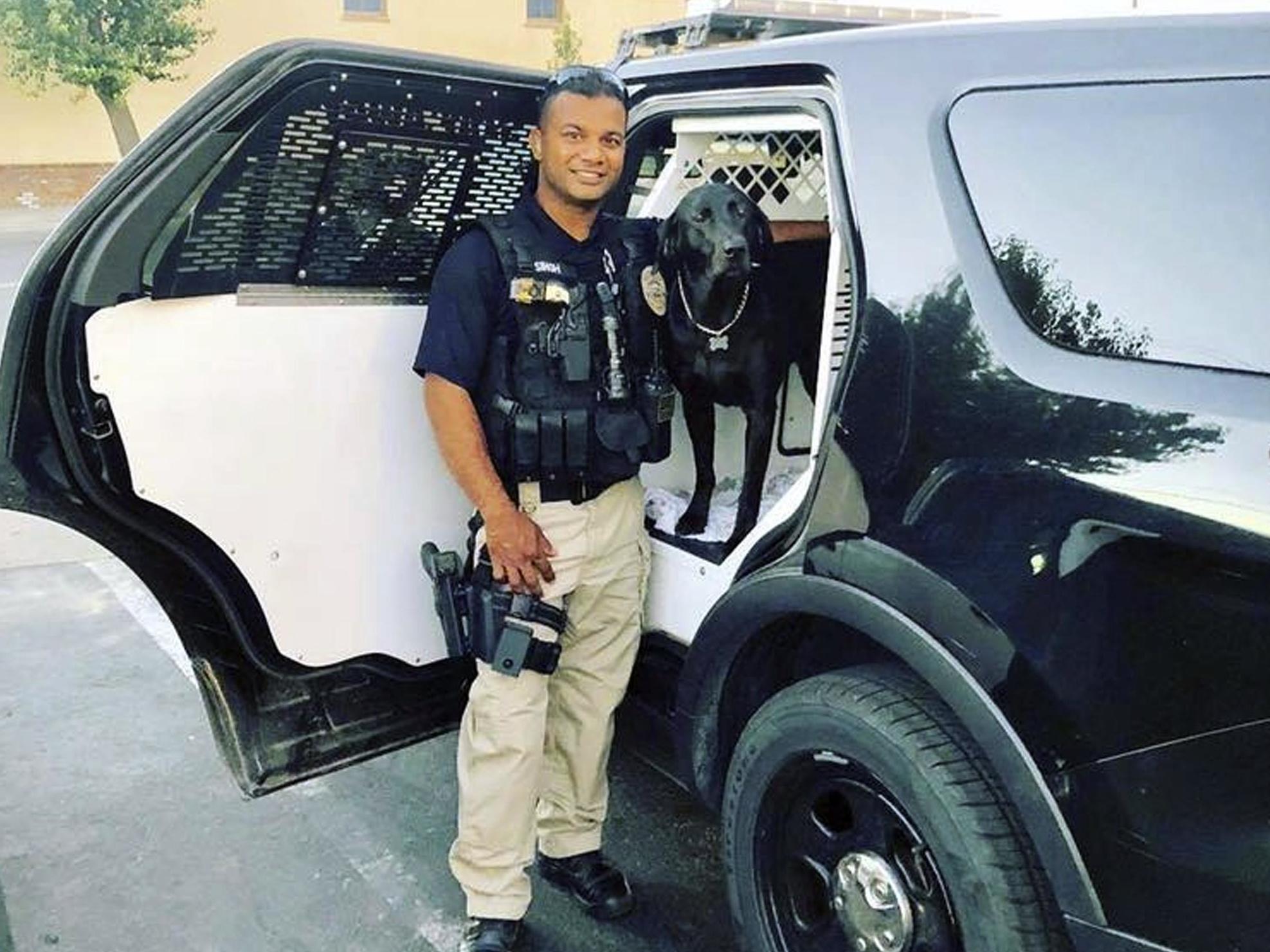 In a photograph released by the Sheriff’s Department, Ronil Singh is shown smiling at a patrol car with a dog