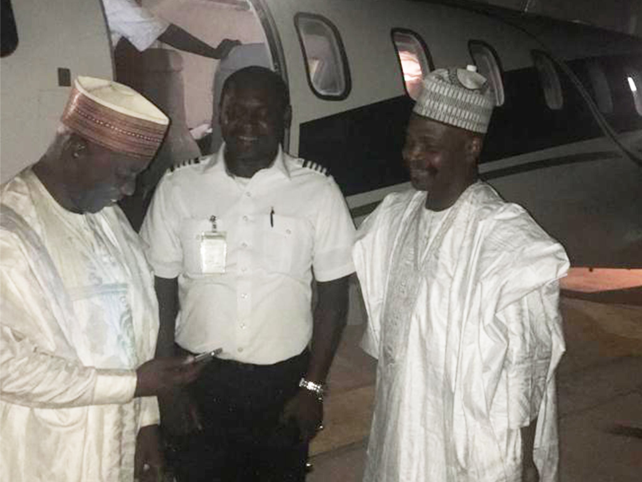 Captain Adam Dilli Ibrahim (centre) was arrested by immigration officials on arrival at Bournemouth International Airport