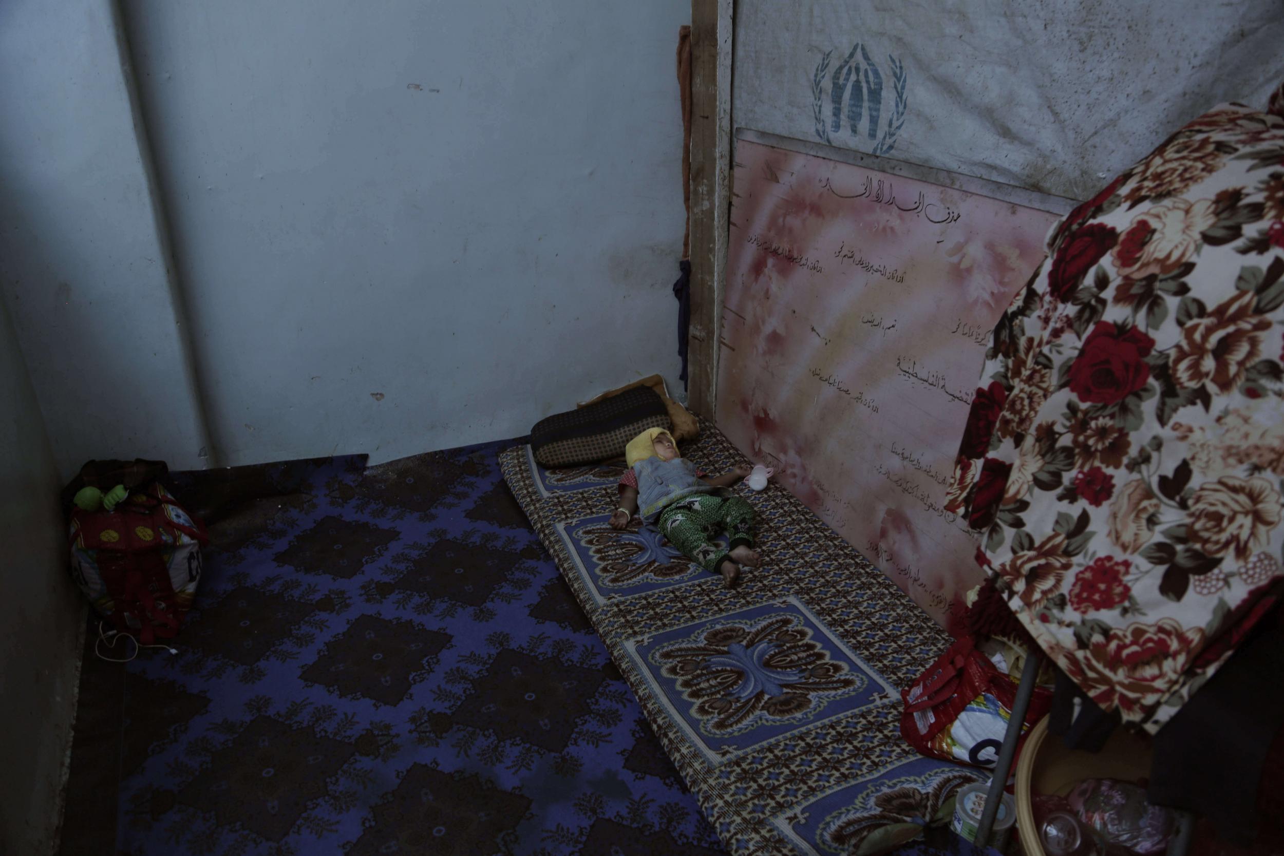 A baby sleeps inside a shelter for displaced persons in Ibb, Yemen, in this 3 Aug 2018 photo.