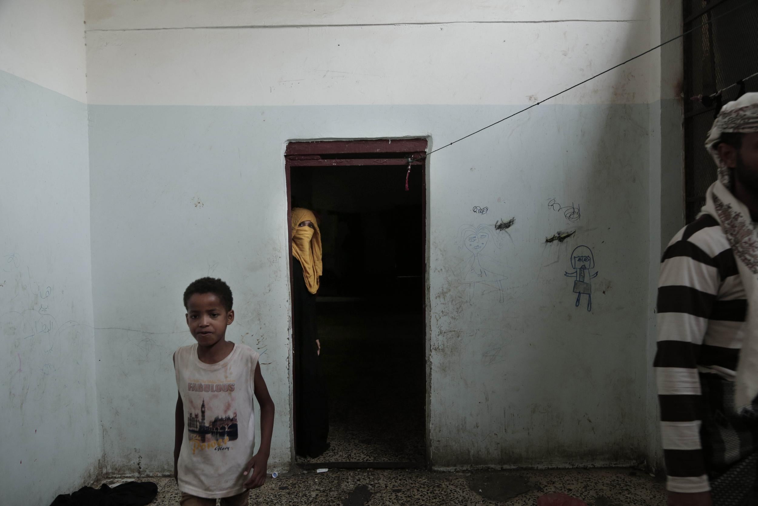 People walk in a shelter for displaced persons in Ibb, Yemen, in this 3 Aug 2018 photo.