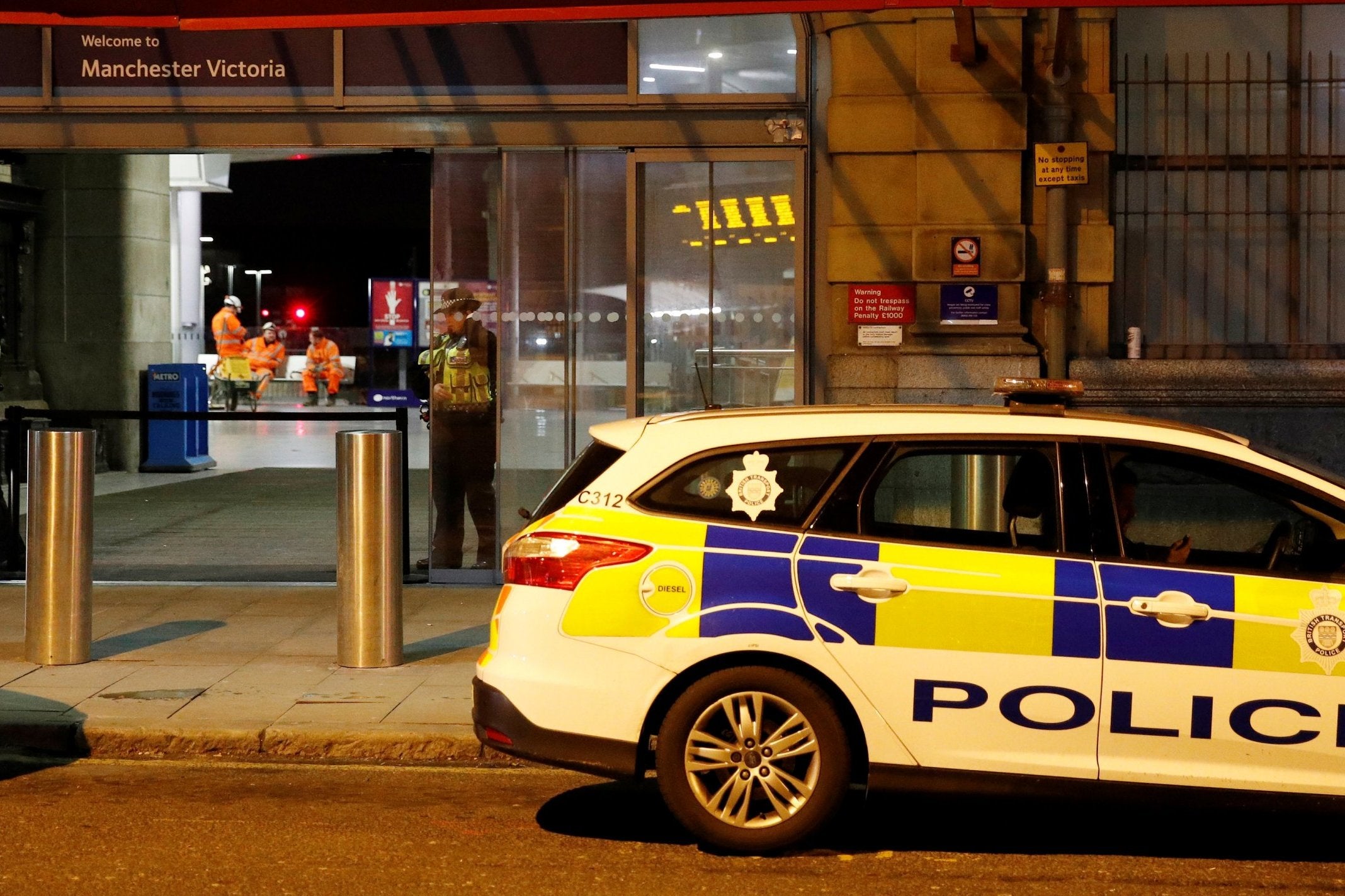 Police officers stand at the end of a tram platform following the stabbing