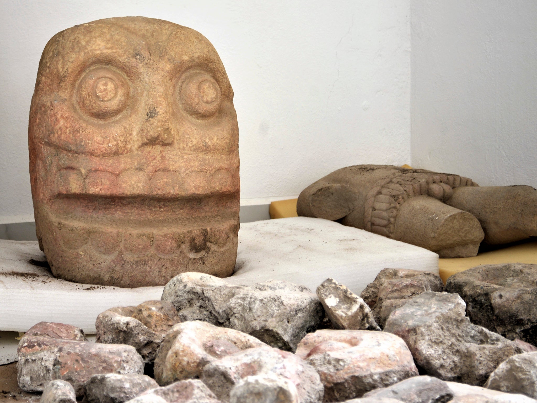 A skull-like stone carving and stone trunk depicting the Flayed Lord