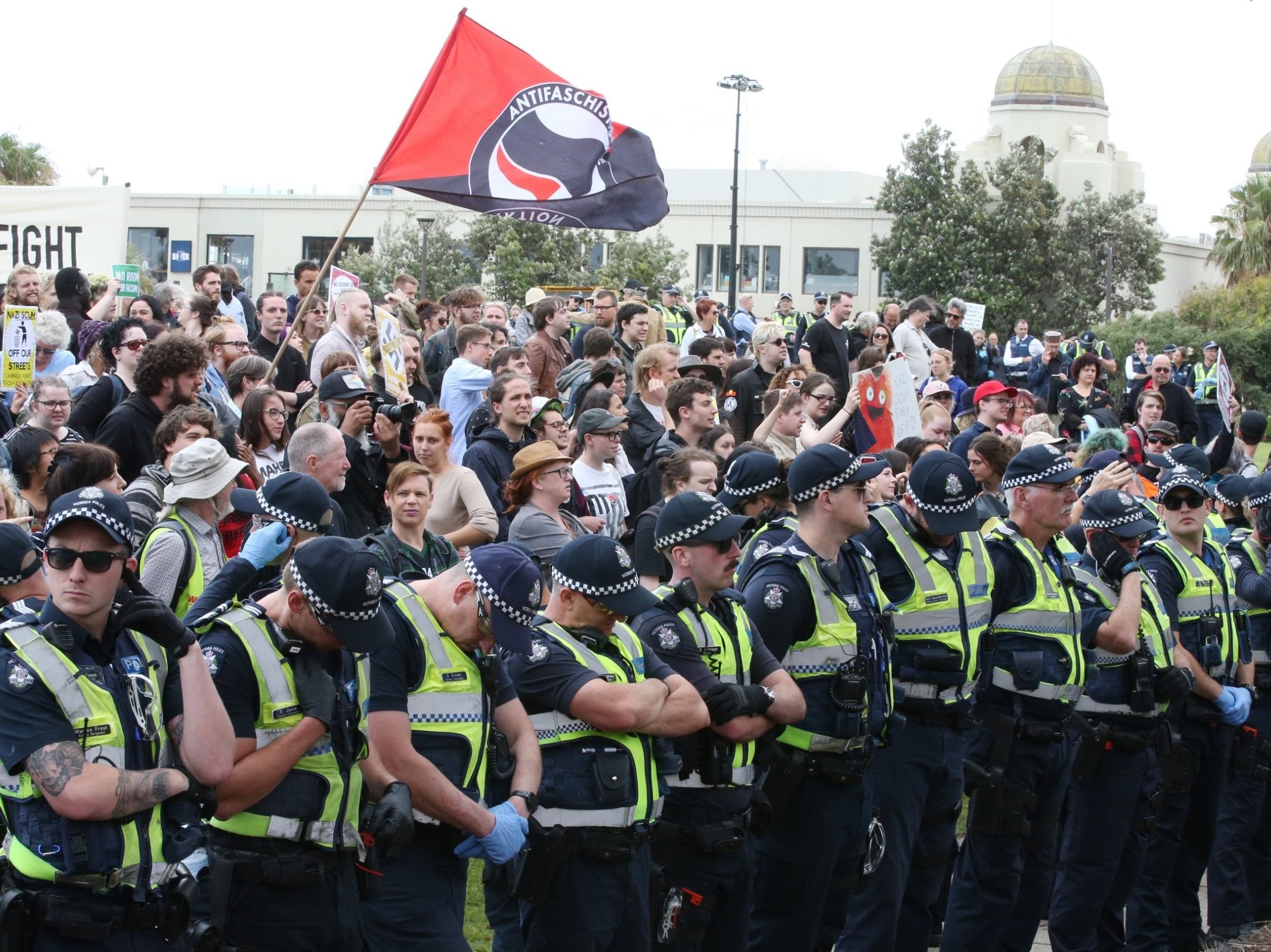 A line of police officers keeps protesters apart on the St Kilda foreshore in Melbourne, Victoria, Australia, 5 January 2019