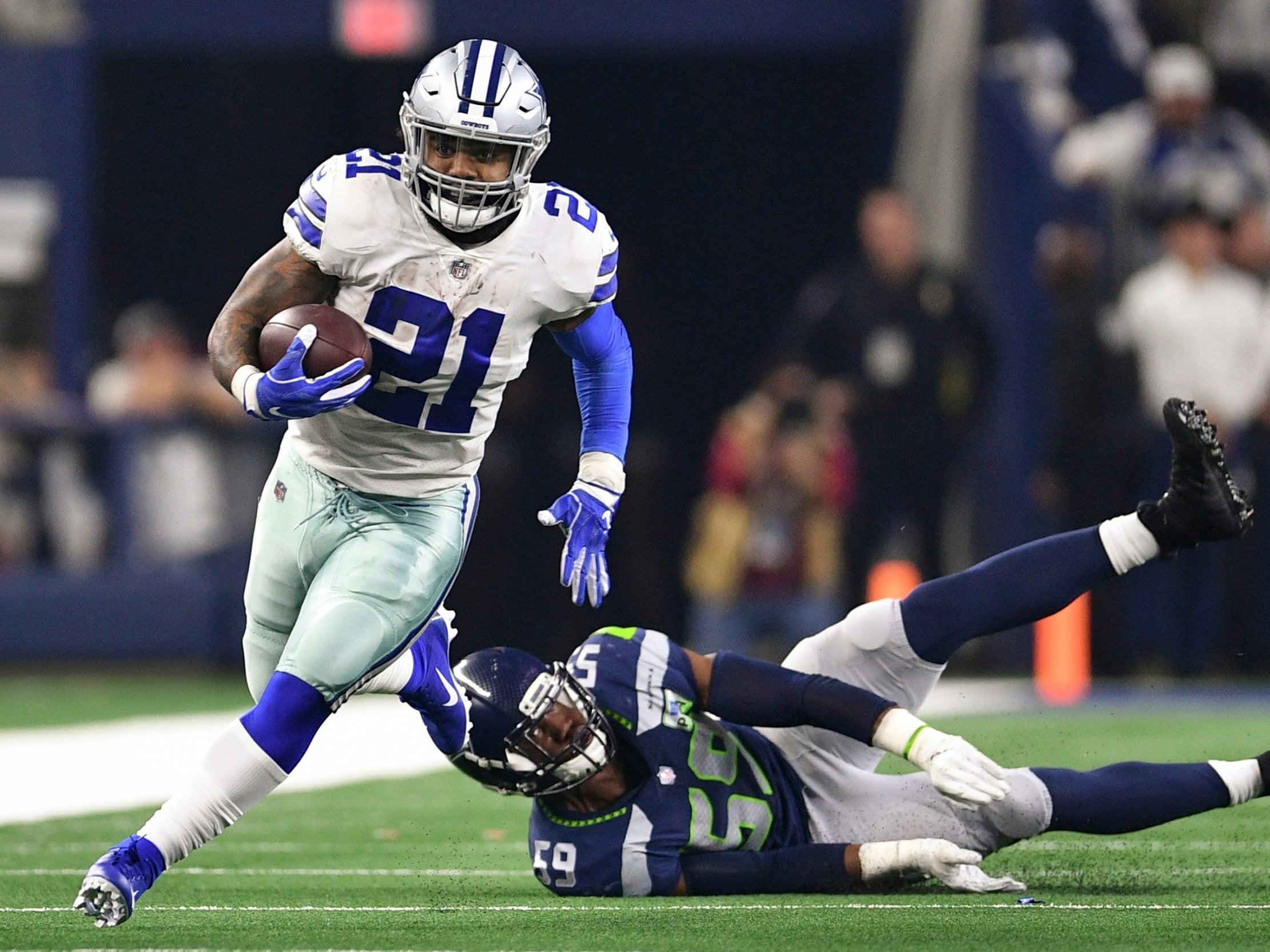 Ezekiel Elliott (21) runs past Seattle Seahawks linebacker Jake Martin (59)