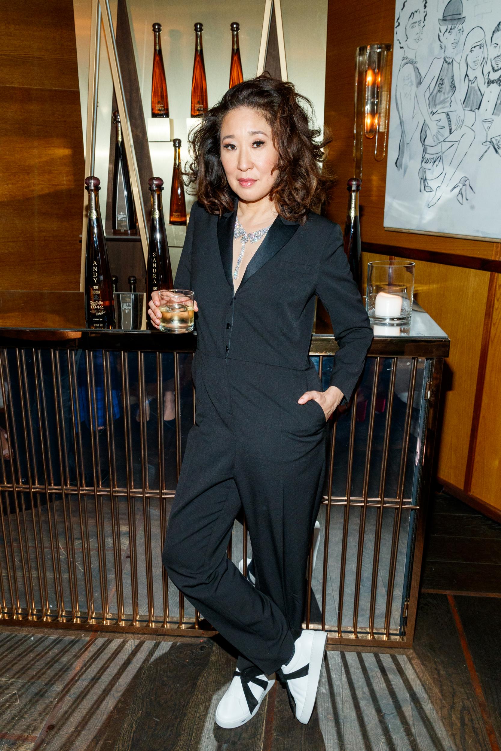 Sandra Oh wearing a tuxedo jumpsuit by Gwyneth Paltrow's Goop fashion line G. Label and trainers by Alexandre Birman