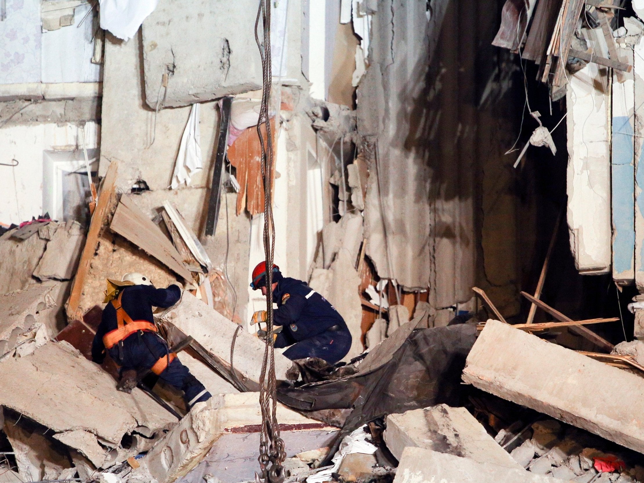 Hundreds of rescue workers search through shards of concrete for survivors of the building collapse