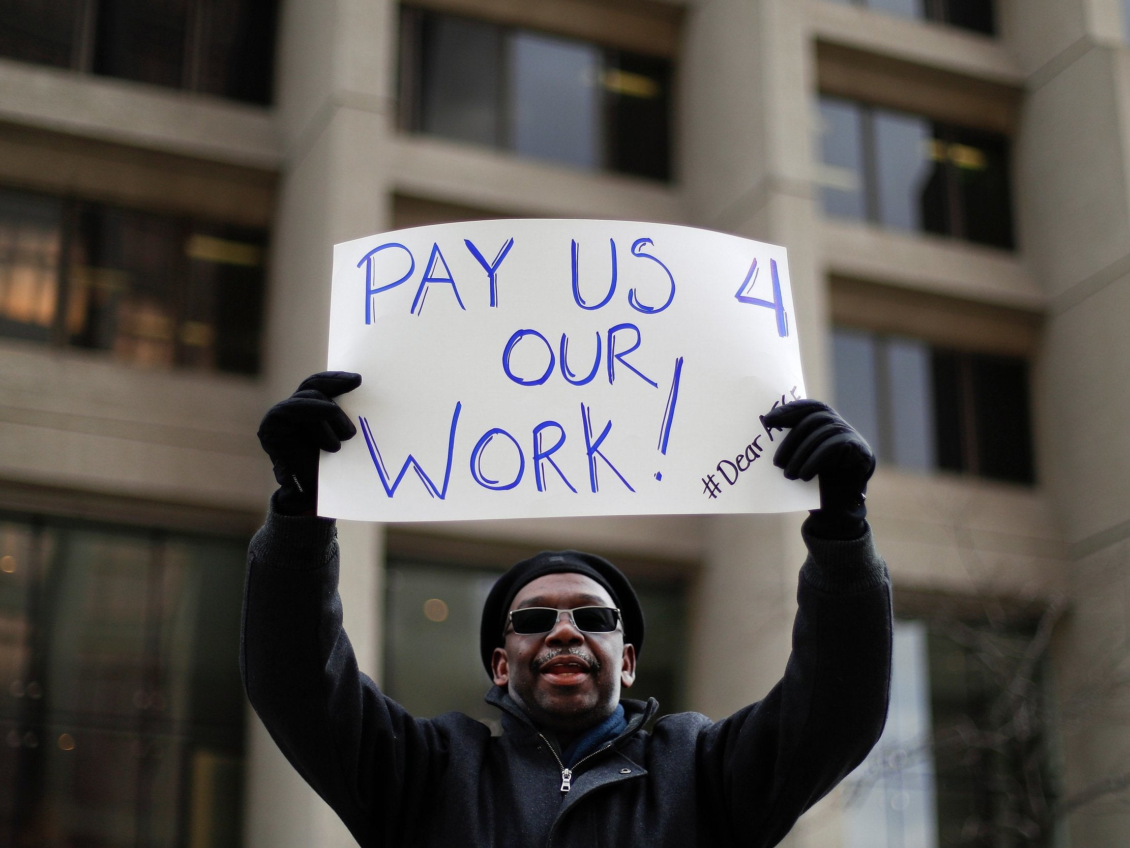 Christopher Belcher, a Department of Veterans Affairs employee, calls for an end to the partial government shutdown during a rally in Detroit on Thursday