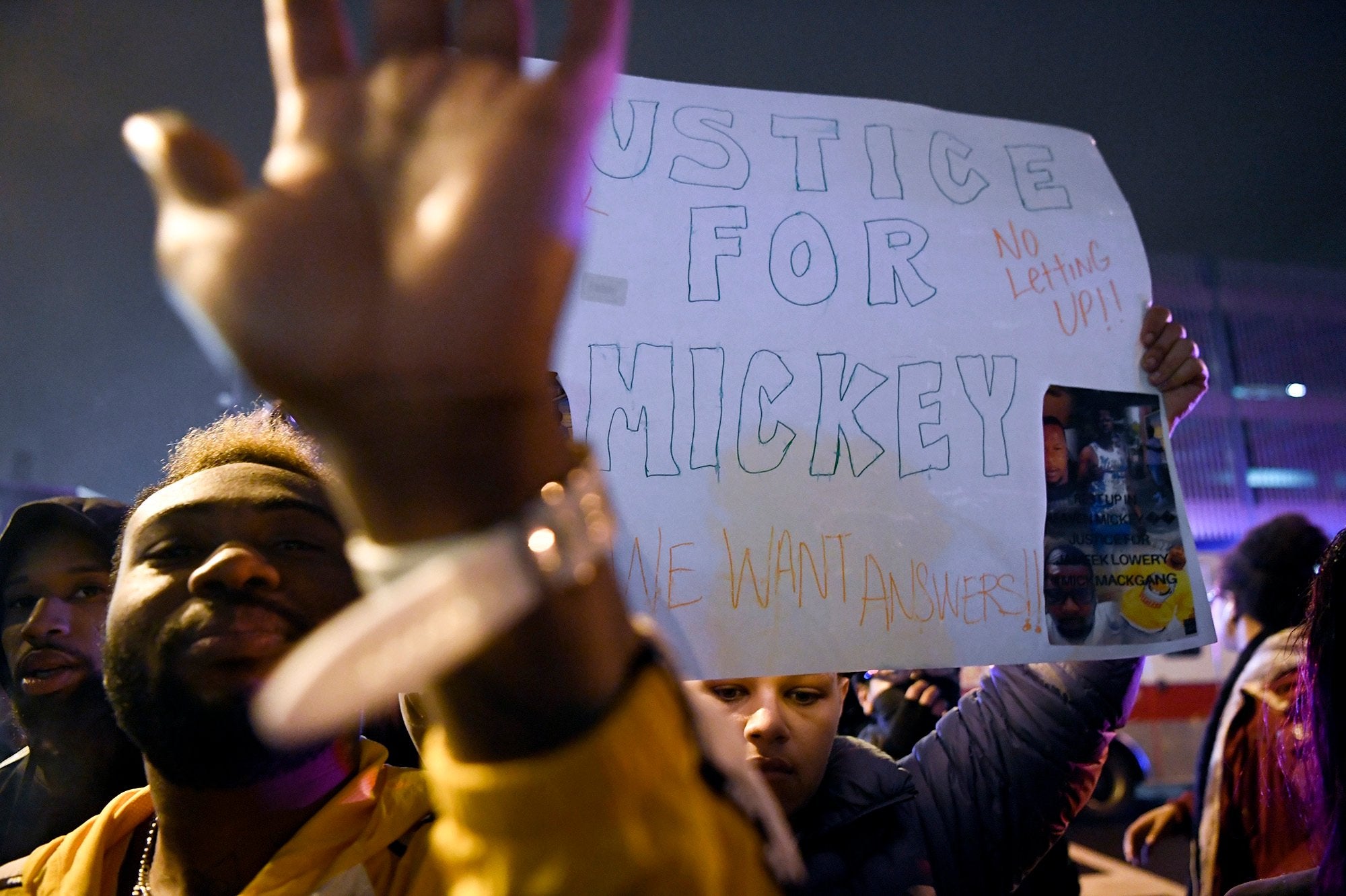 A protester tries to block the camera as they face Paterson police officers during a rally on 8 January 2019