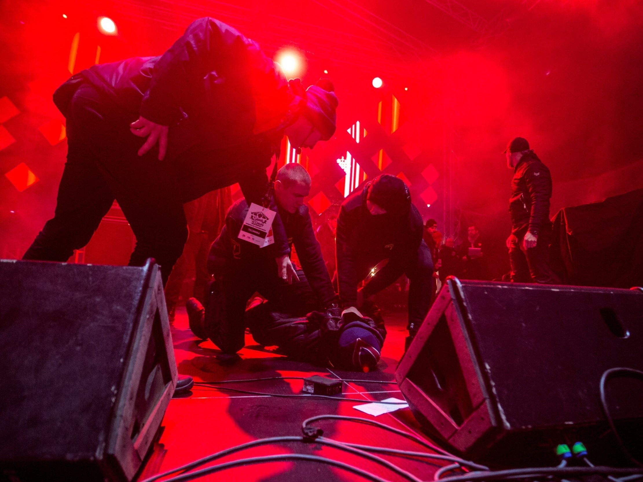 A man is held on the ground by security staff after the attack on the mayor of Gdansk during a charity event