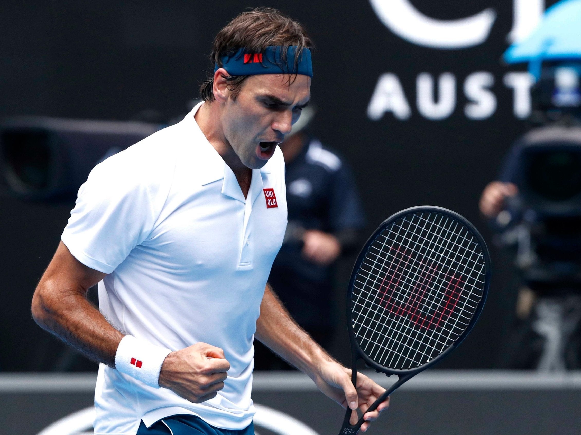 Roger Federer celebrates after beating Dan Evans to reach the third round