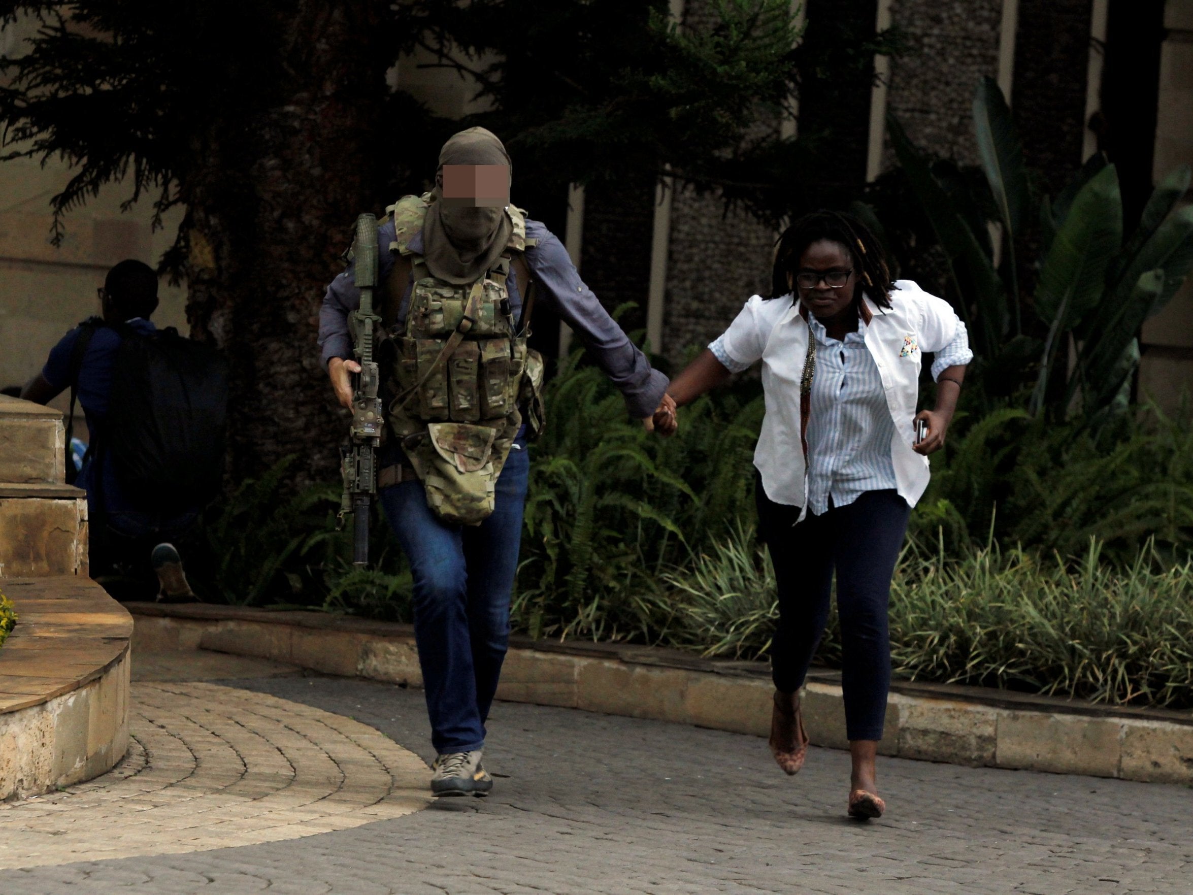 The SAS soldier evacuates an injured woman from the scene (Reuters)