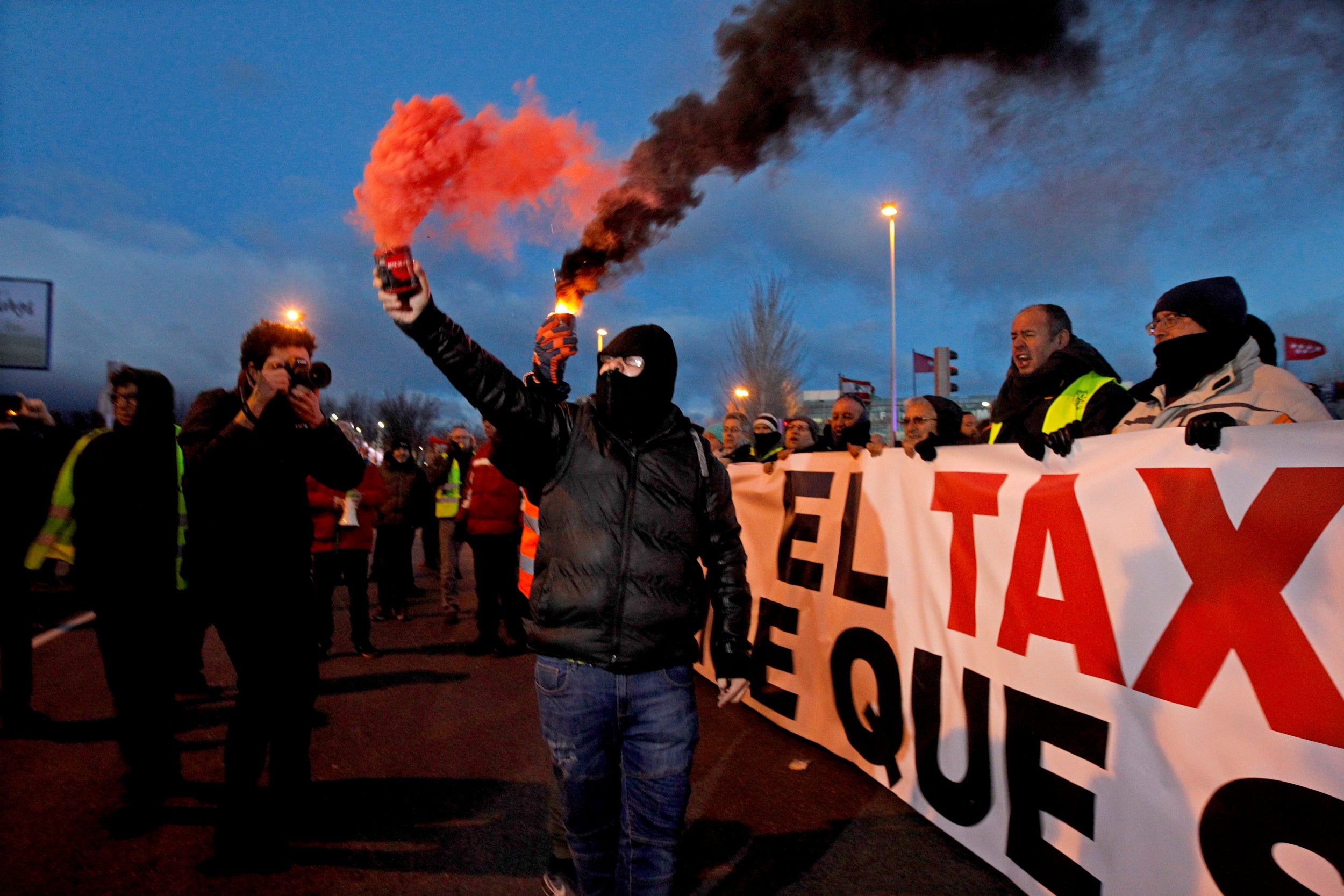 Demonstrators hold a huge banner reading 'Madrid's taxi demands that the law has to be enforced' as drivers protest outside IFEMA Convention and Congress Center, against the regulation of ride-hailing and car-sharing services such as Uber and Cabify