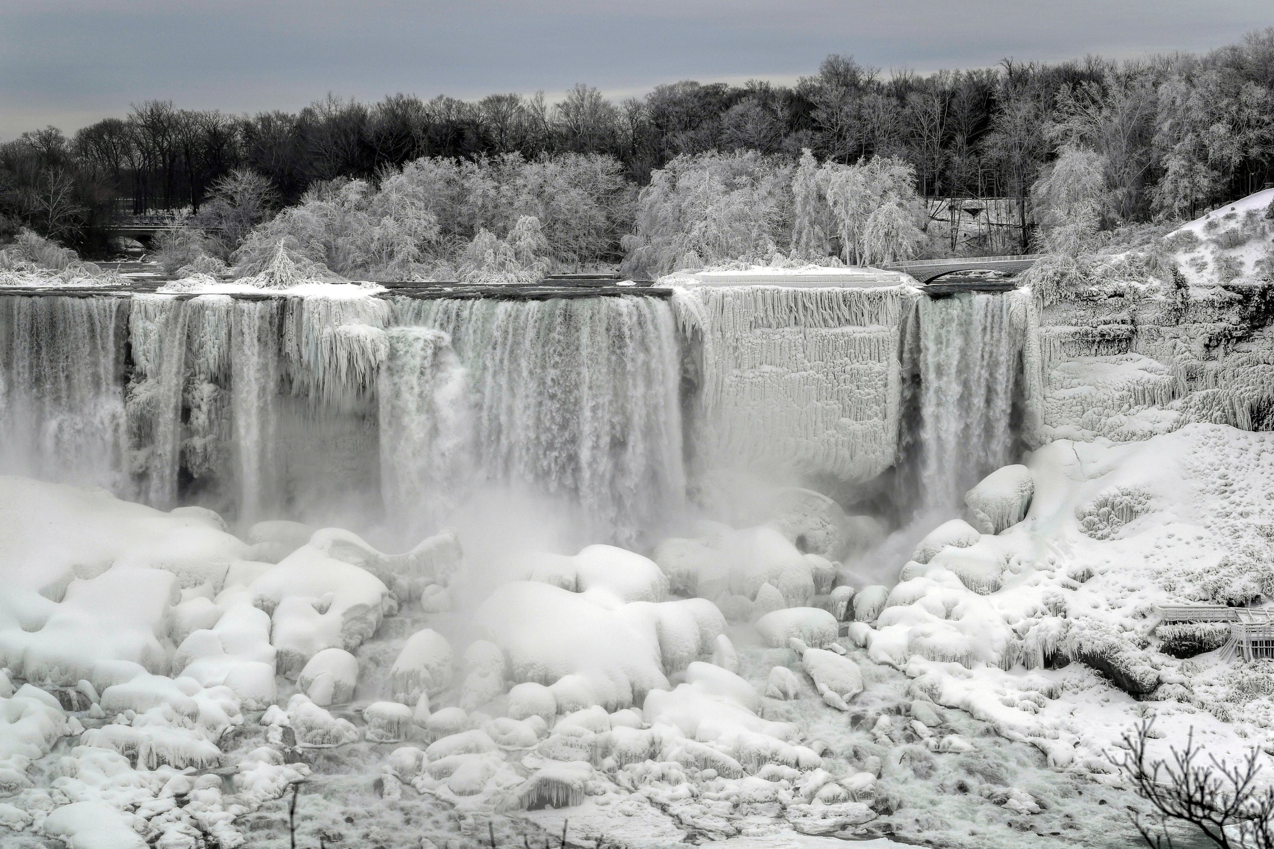 Water flows around ice, formed on the American Falls in Niagara Falls, due to subzero temperatures, viewed from the Canadian side, in Ontario